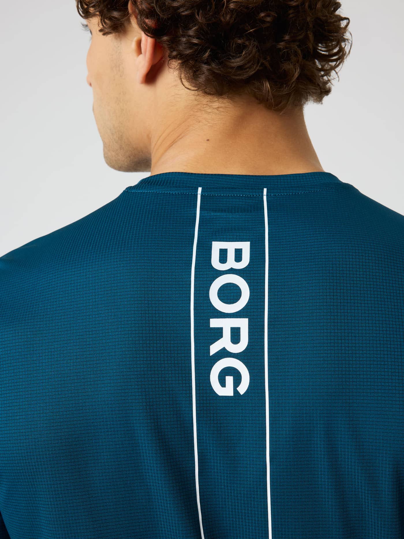 Back view of the Ace Light T-Shirt in Reflecting Pond (Green) featuring a white vertical BORG logo for tennis. - Image 4