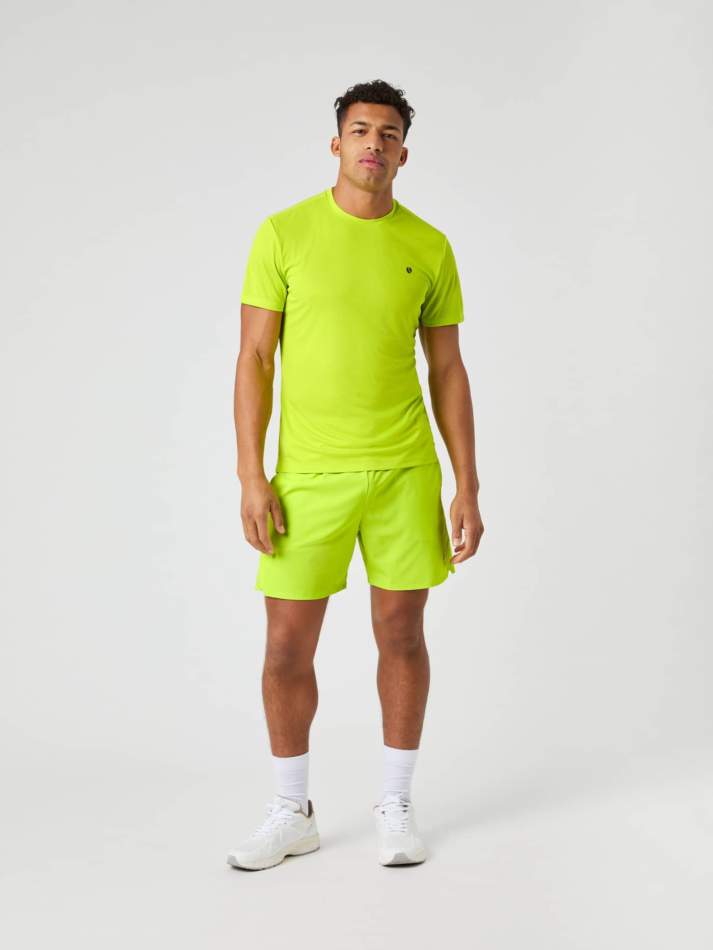 Front view of a male model wearing the Björn Borg Ace Light T-shirt and matching shorts in acid lime. - Image 3
