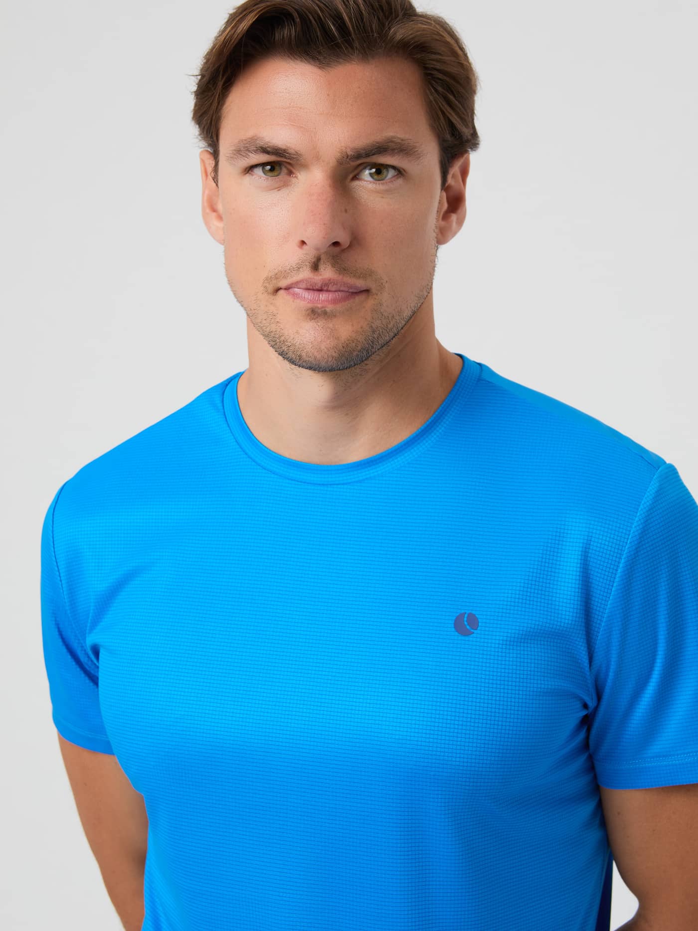 Close-up front view of a man wearing the Björn Borg Ace Light T-shirt in Electric Blue Lemonade. - Image 4