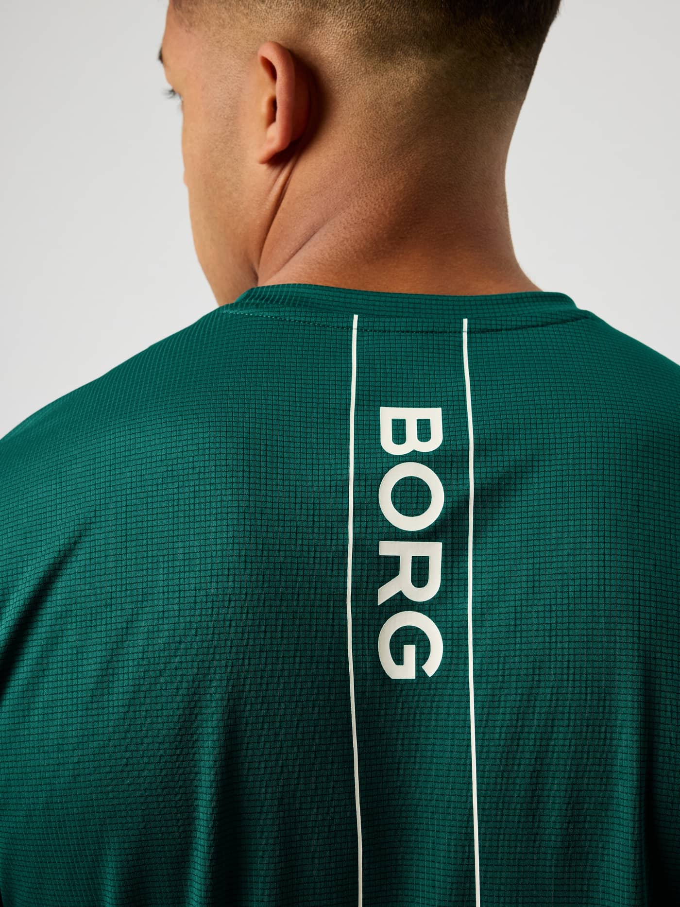 Vista posterior de la Ace Light T-Shirt en Posy Green (Verde) con logotipo BORG blanco para rendimiento en tenis. - Image 4