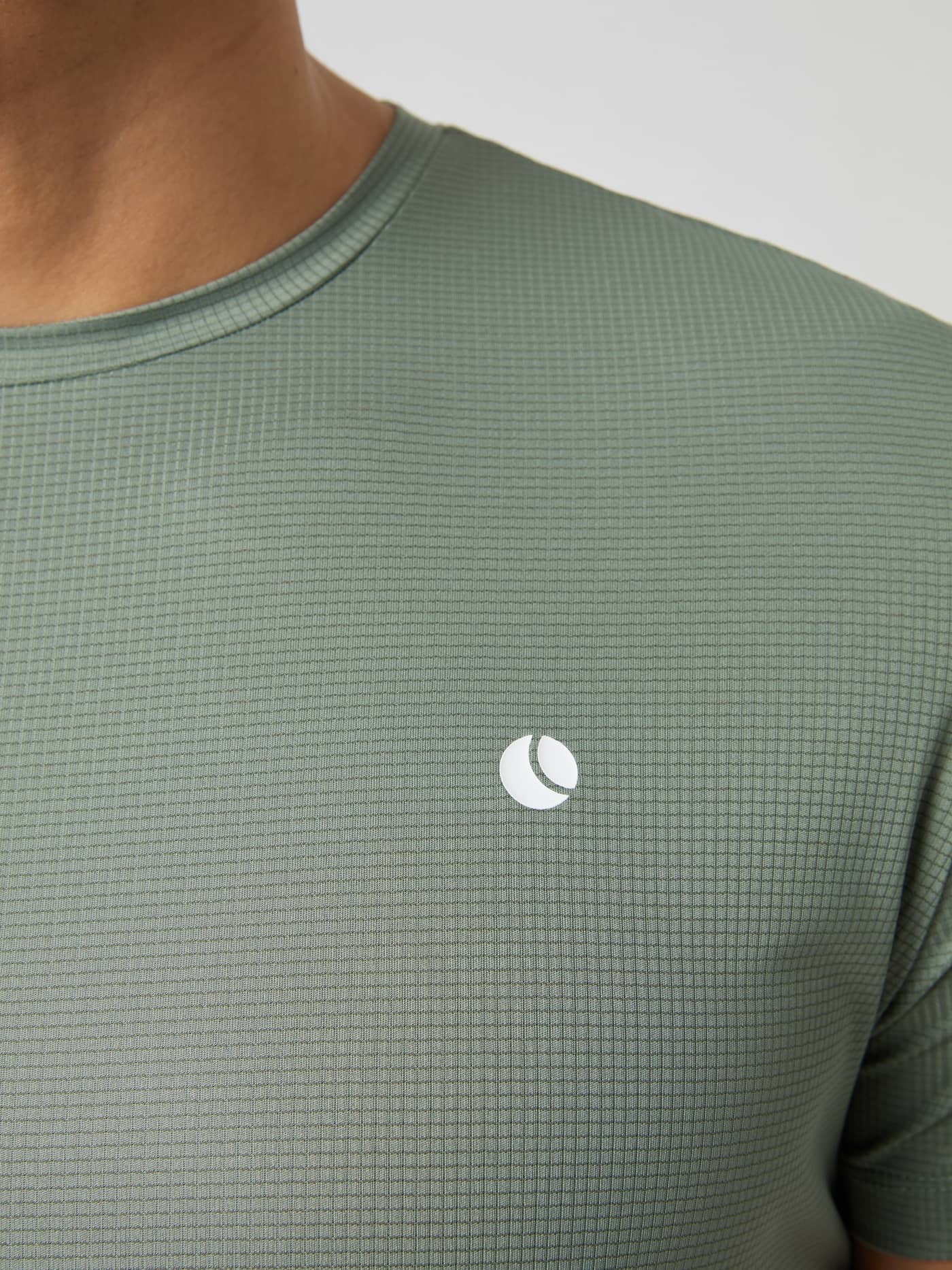 Detailed close-up of the Björn Borg Ace Light T-shirt in Agave Green, highlighting its textured fabric and chest logo. - Image 5