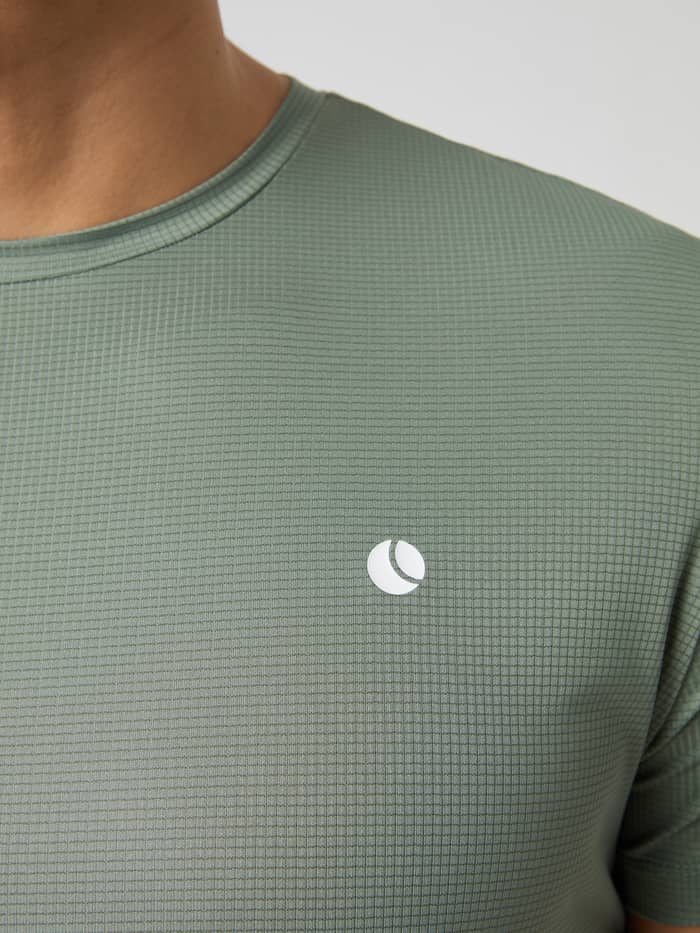 Detailed close-up of the Björn Borg Ace Light T-shirt in Agave Green, highlighting its textured fabric and chest logo.