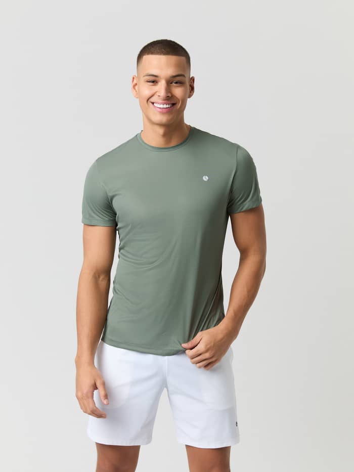 Front view of a male model wearing the Björn Borg Ace Light T-shirt in Agave Green, paired with white shorts.