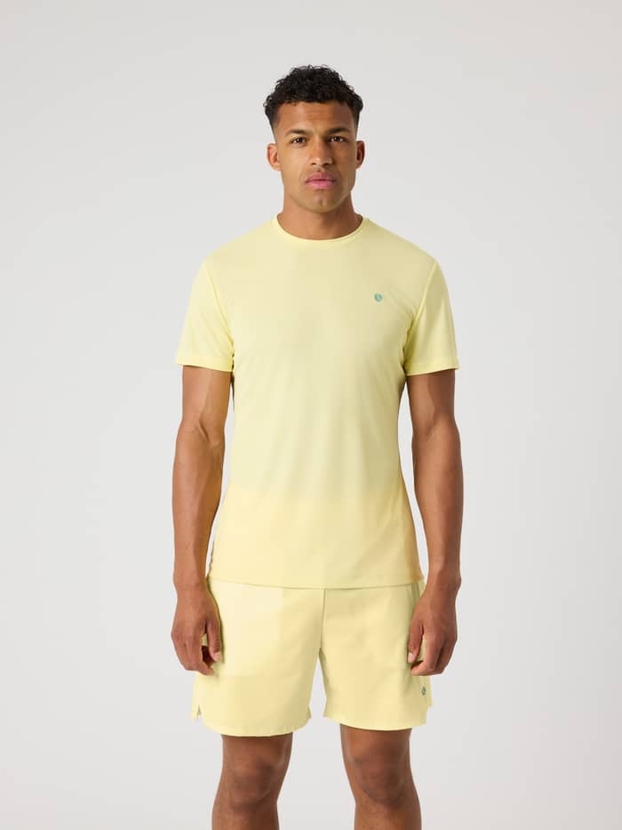 Vorderansicht eines Mannes im Björn Borg Ace Light T-Shirt in Lemonade (Gelb) mit blaugrünem Logo für Tennis.