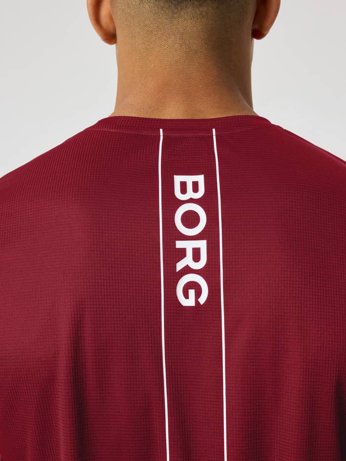 Back view of the Ace Light T-Shirt in Cabernet (red) highlighting the white BORG logo stripe for tennis.