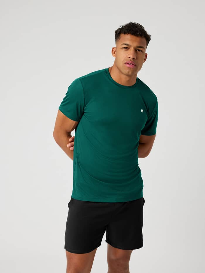 Vorderansicht eines Mannes im stylischen Björn Borg Ace Light T-Shirt in Posy Green (Grün) mit weißem Tennis-Logo.