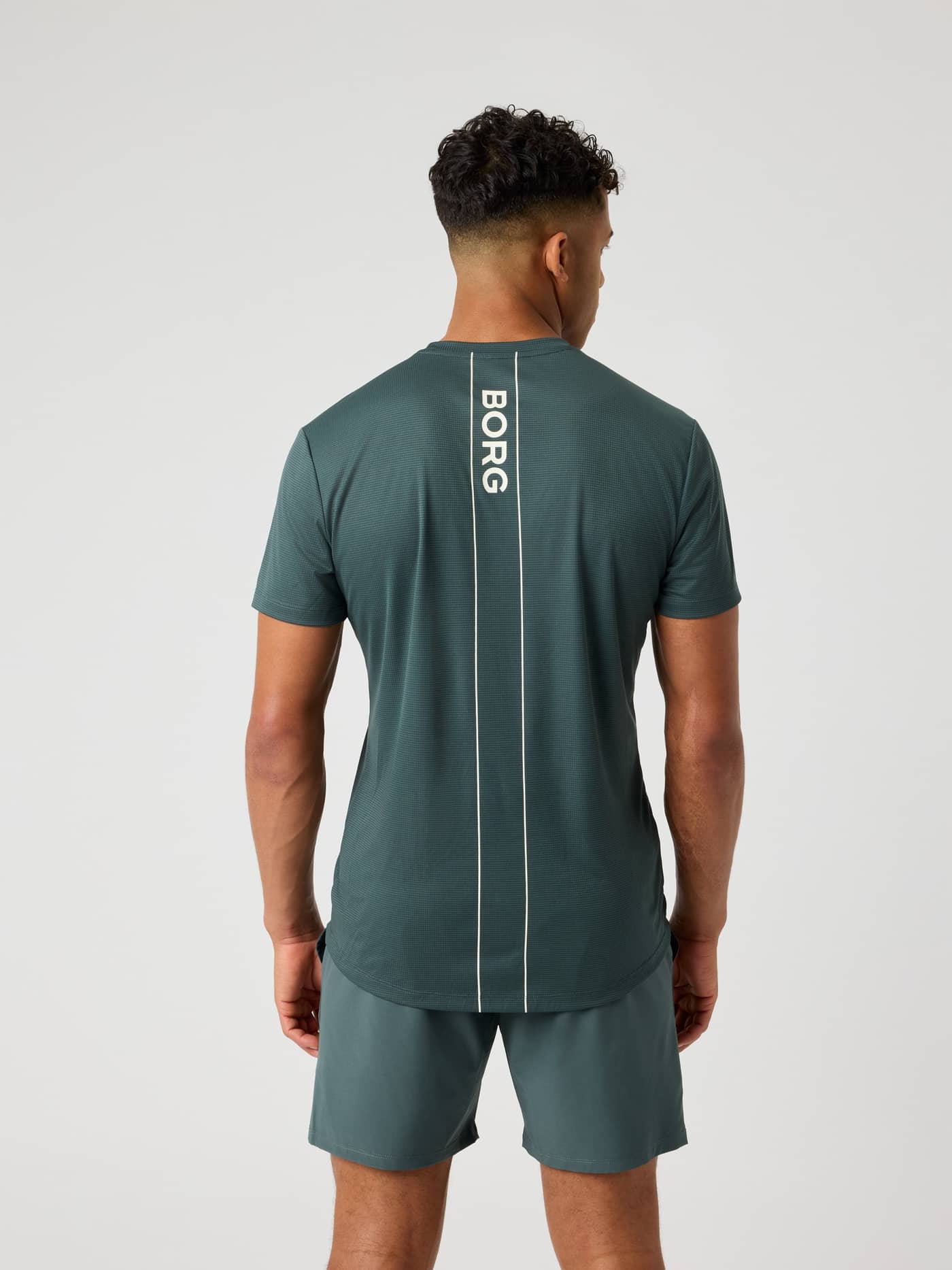 Ace Light T-Shirt i Urban Chic (Grøn) set bagfra med en vertikal logostribe til tennis. - Image 2