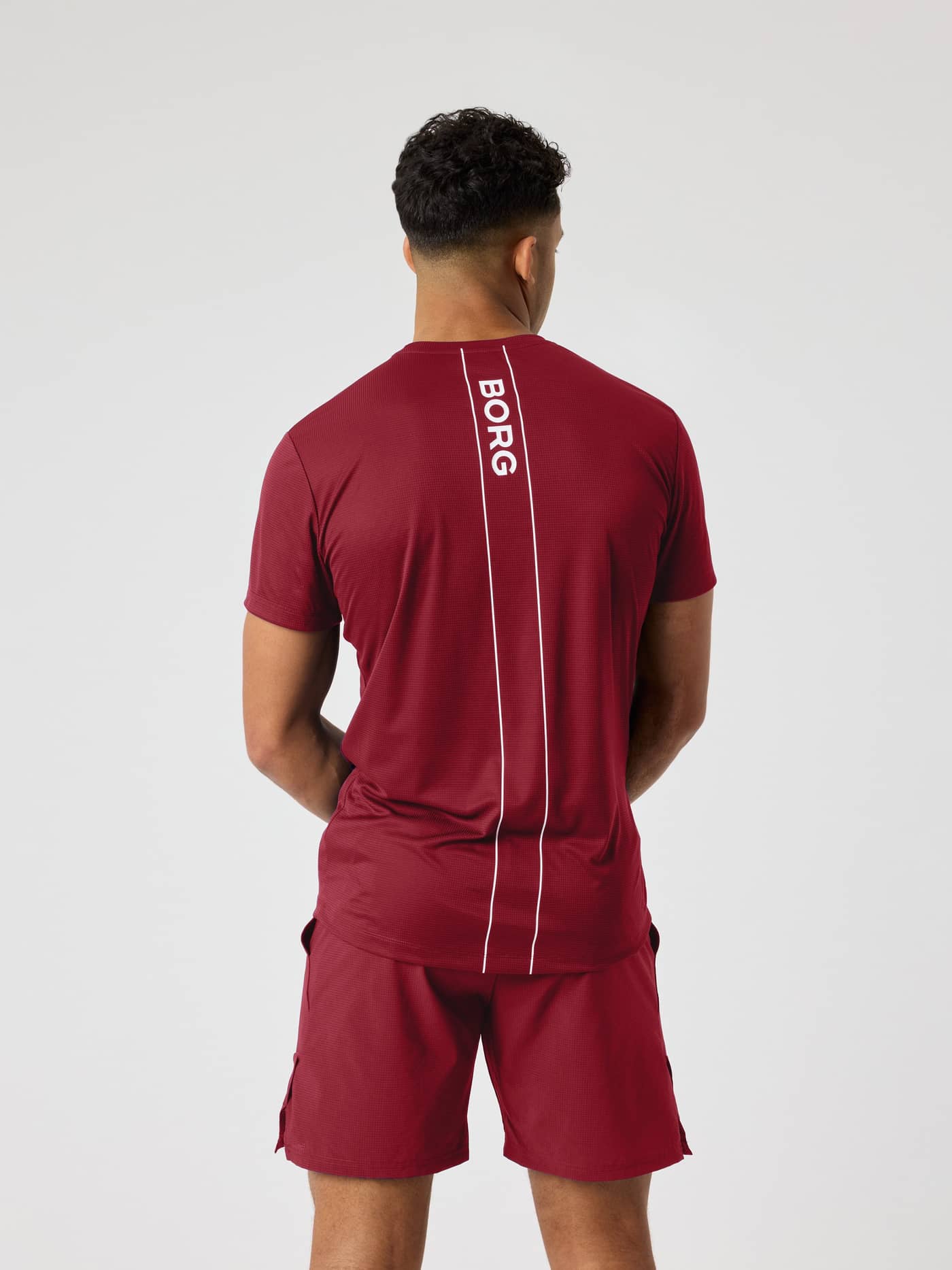 Rückansicht des Ace Light T-Shirt in Cabernet (rot) mit weißem Logostreifen auf dem Rücken für Tennis. - Image 2