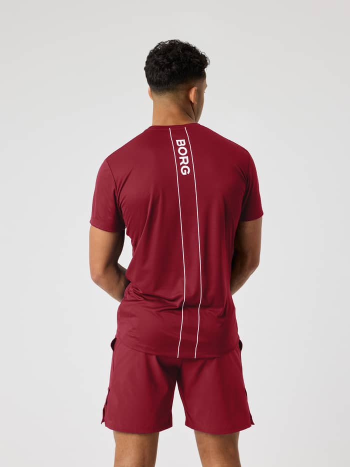Back view of the Ace Light T-Shirt in Cabernet (red) highlighting the white logo stripe on the back for tennis.
