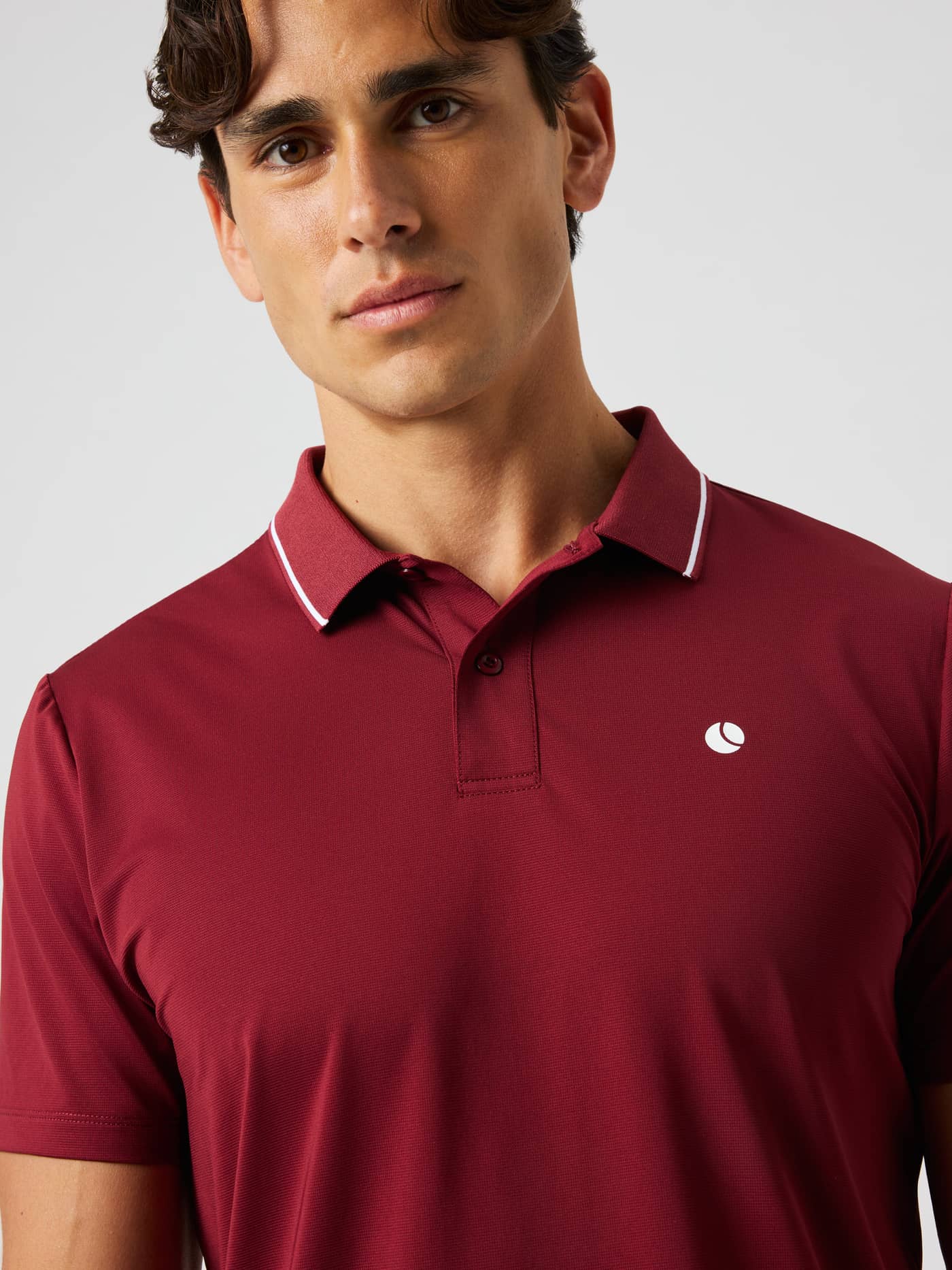 Close-up of a model wearing the Björn Borg Ace Polo Shirt in Cabernet (Red) for tennis, showing the flat-knit collar. - Image 5
