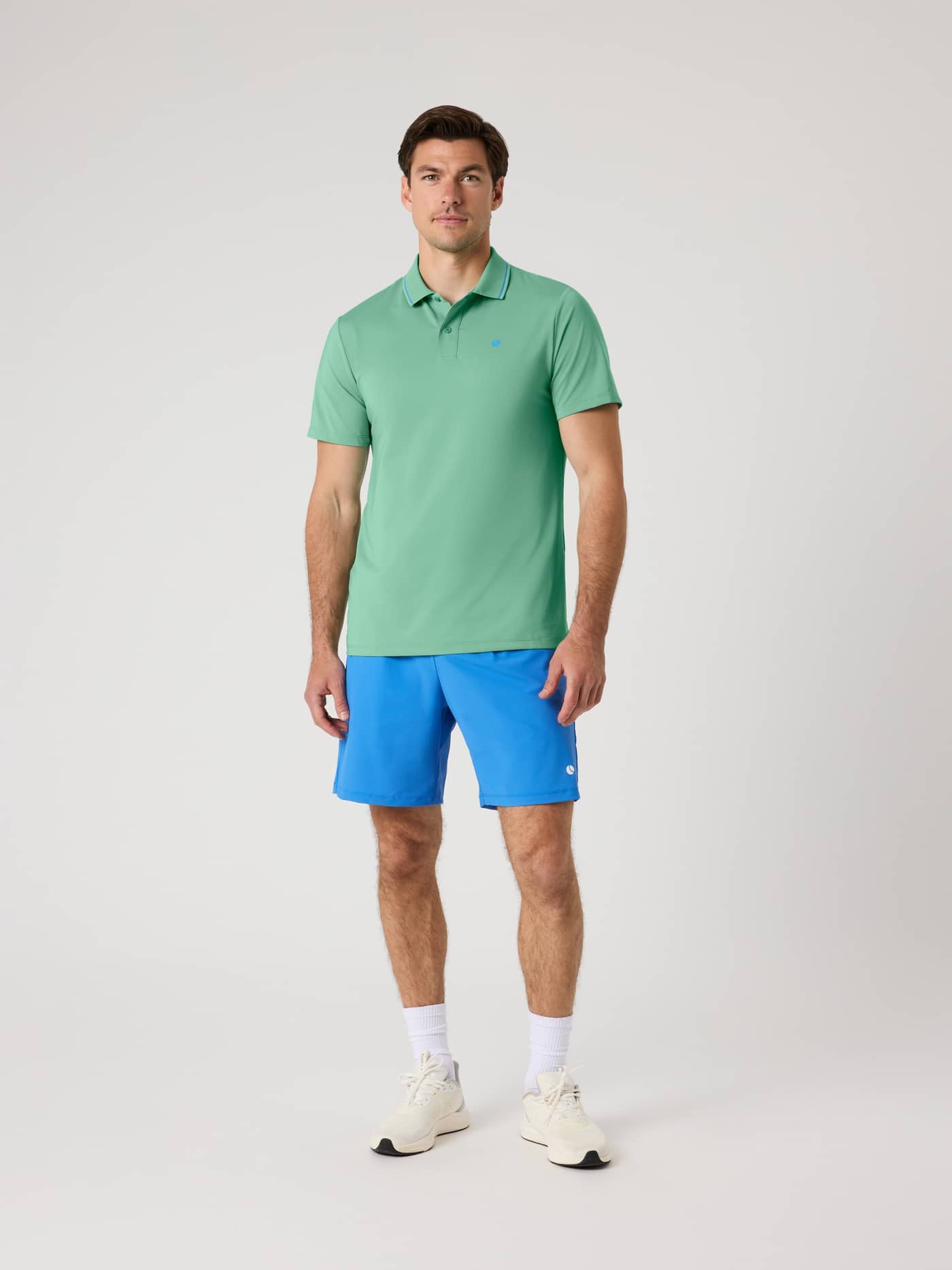 Front view of a man in the Malachite Green (Green) Björn Borg Ace Polo Shirt with a blue logo for performance tennis. - Image 3