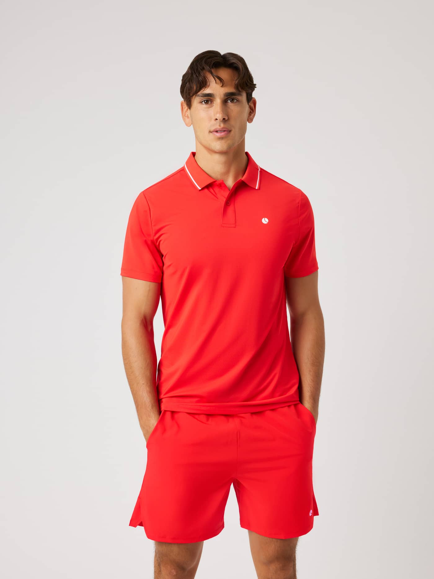 Front view of a model wearing the Ace Polo Shirt in Flame Scarlet (Red), a breathable style for tennis performance. - Image 2