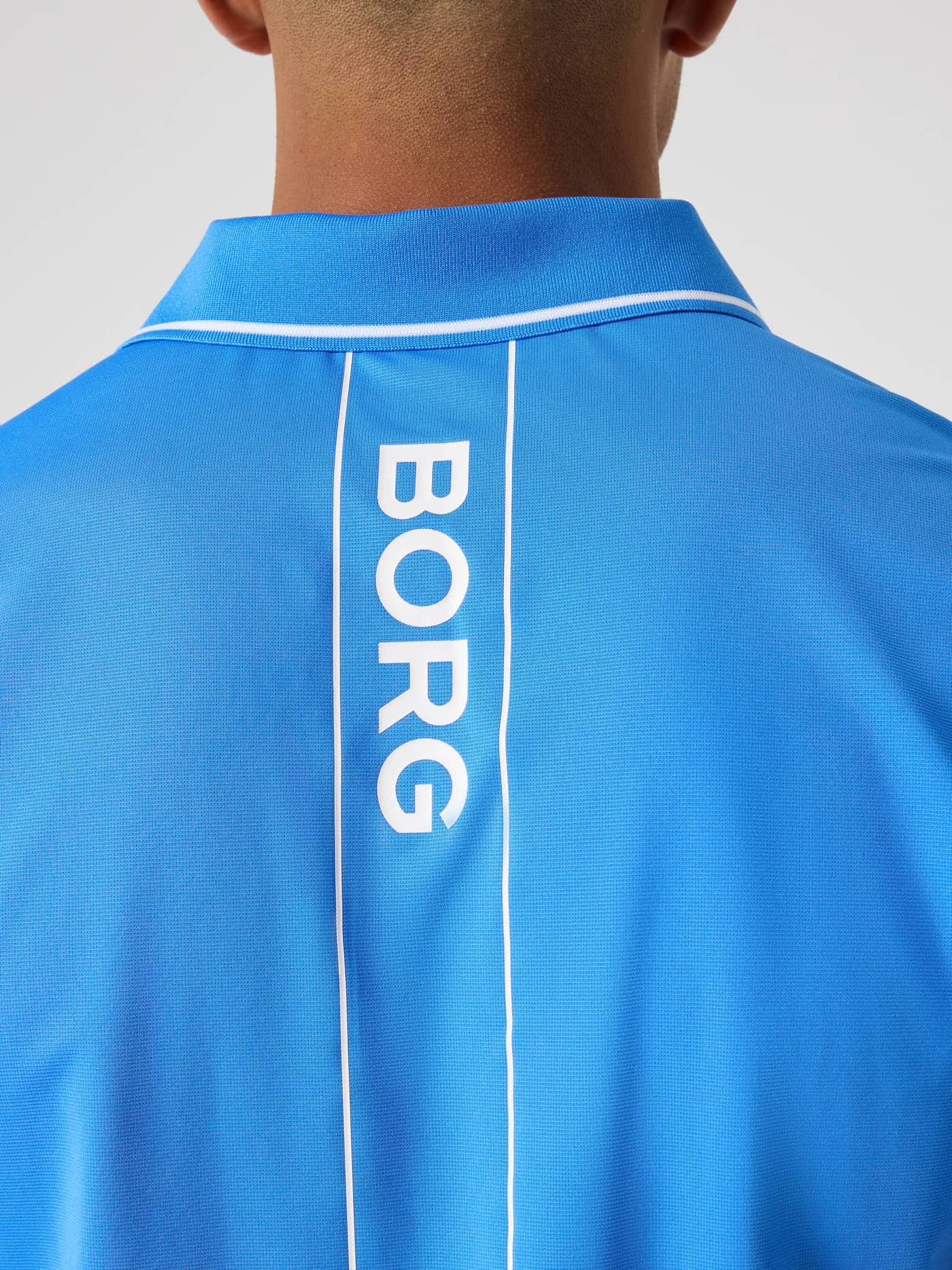 Detailed back view of the Ace Polo Shirt in Palace Blue (Blue) featuring a white BORG logo, designed for tennis performance. - Image 4