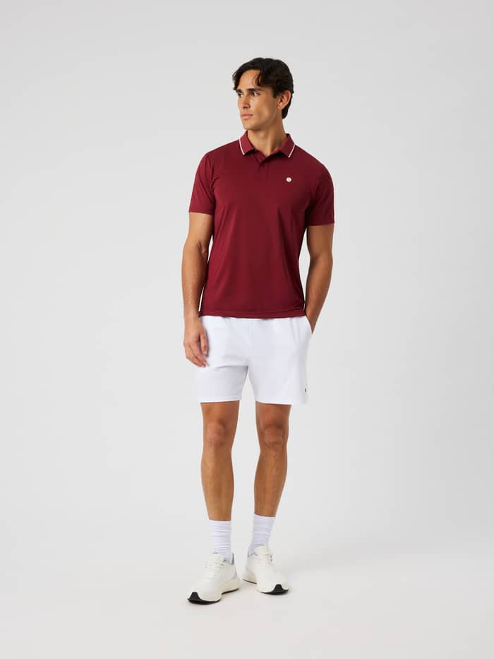 Full-body front view of a model wearing the Ace Polo Shirt in Cabernet for tennis.