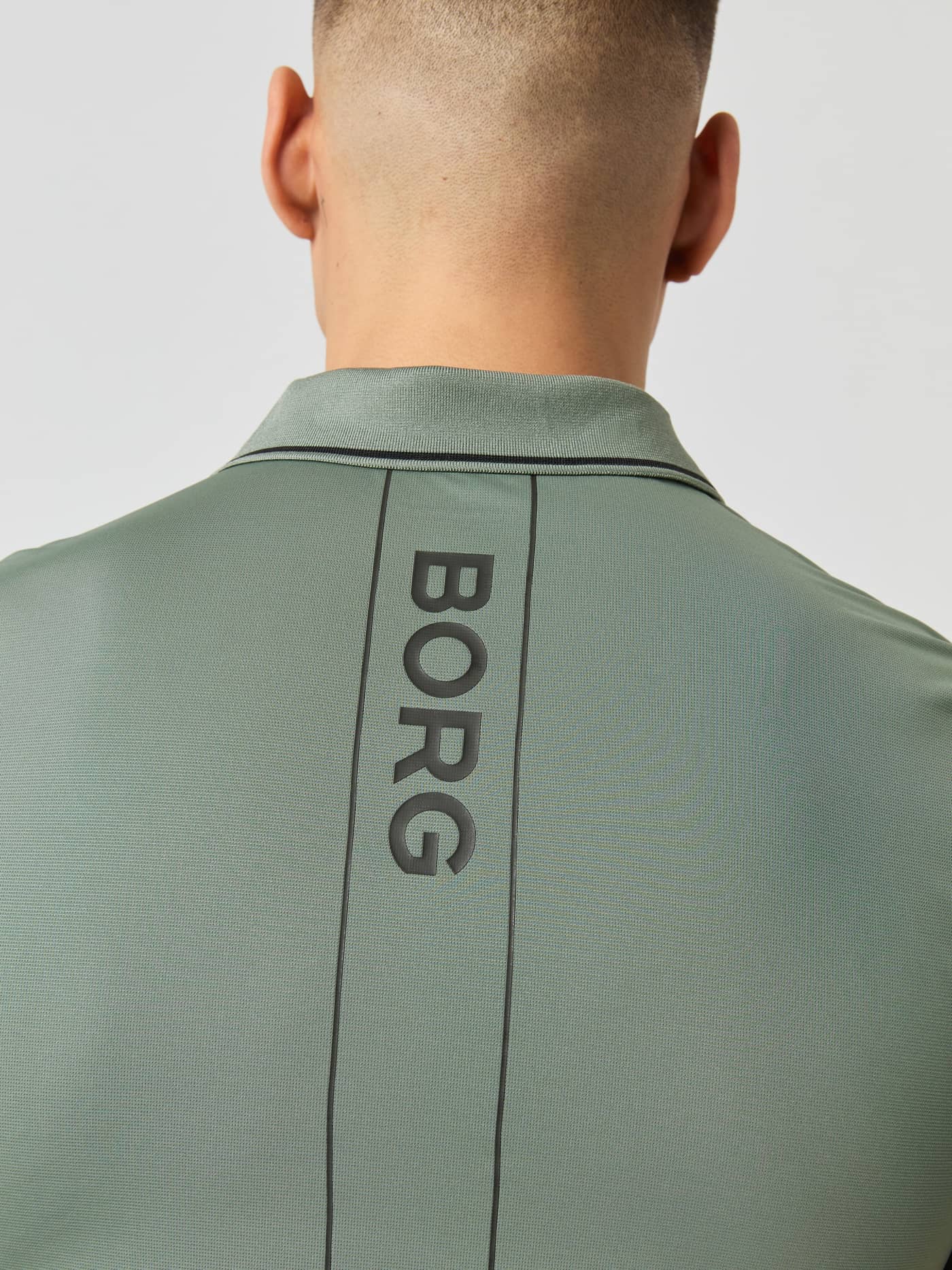 Close-up of the back collar and vertical BORG logo on the men's Ace Polo Shirt in Agave Green. - Image 4