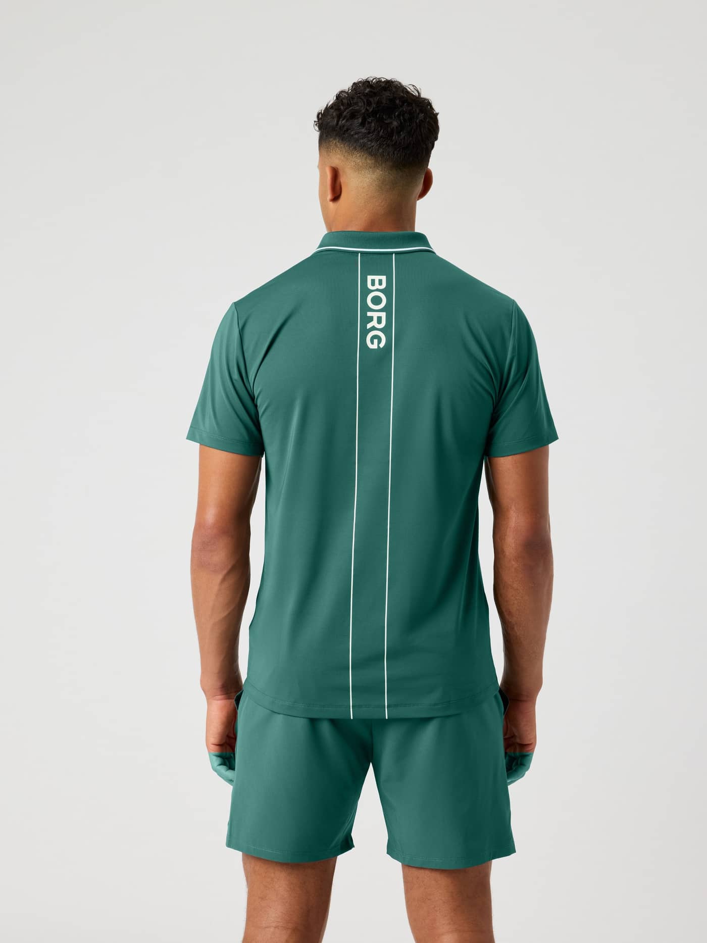 Rückansicht des Ace Polo Shirt in Mallard Green (Grün) mit weißem Logo und Court-Linien für Tennis. - Image 4