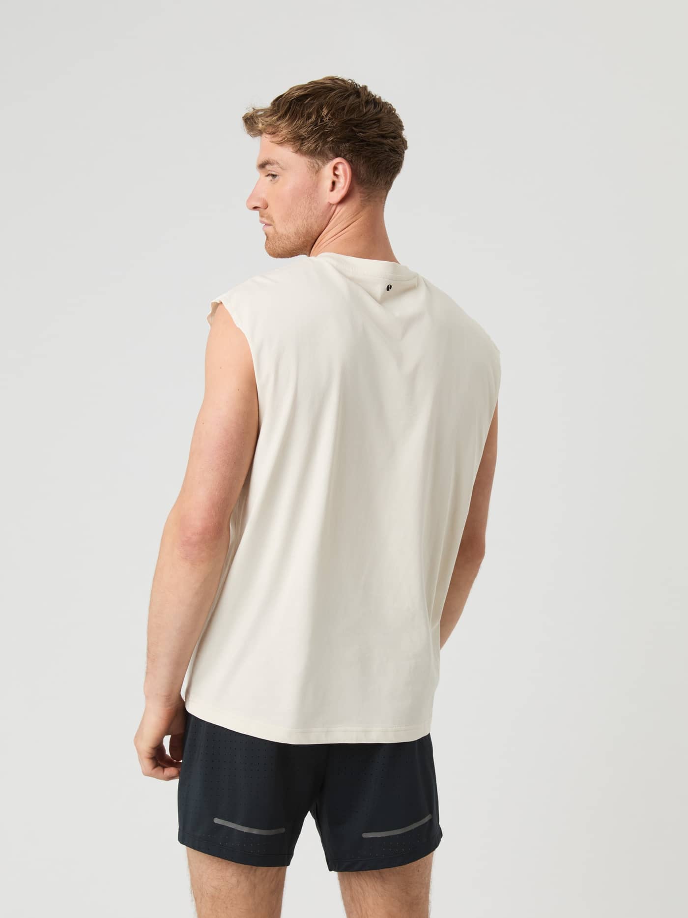 Vue de dos d'un homme portant le Borg Gym Sleeveless T-Shirt en Birch (Blanc), coupe ample pour l'entraînement. - Image 2