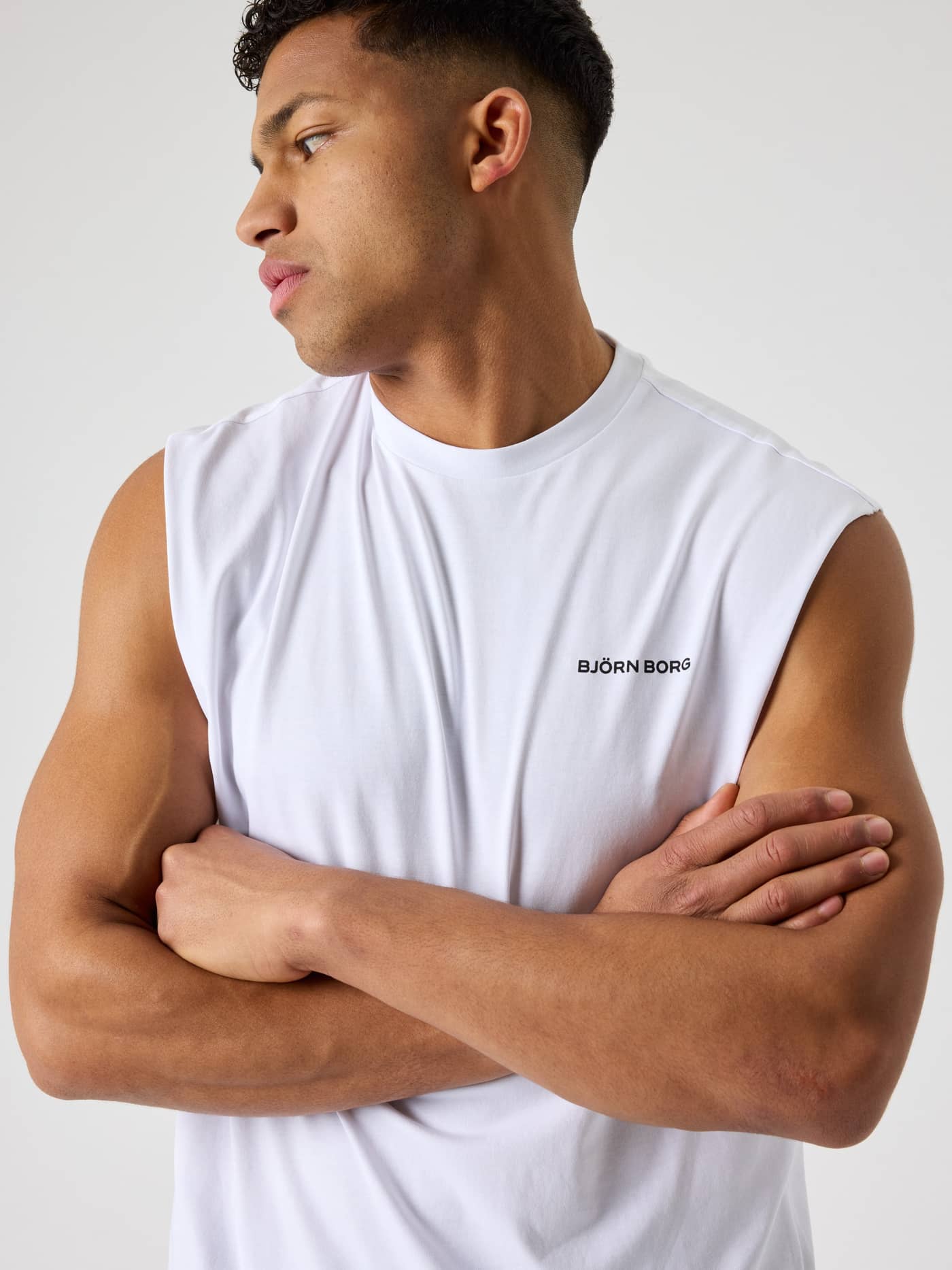 Nahaufnahme eines Mannes im oversized Borg Gym Sleeveless T-Shirt in Brilliant White (Weiß) mit schwarzem Logo für Training. - Image 4