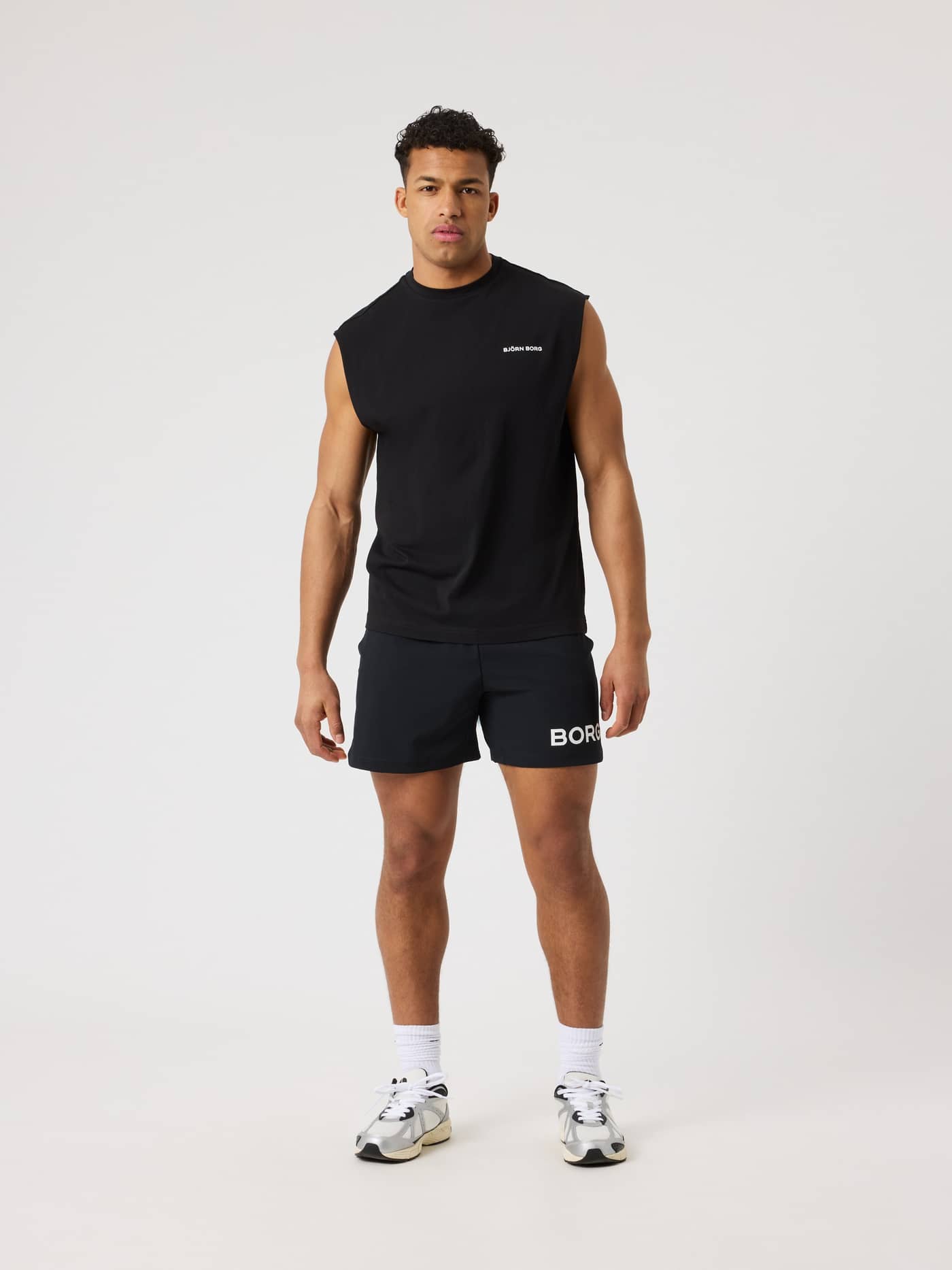 Full-body front view of a man wearing the training Borg Gym Sleeveless T-Shirt in Black Beauty (Black) with a white logo. - Image 3