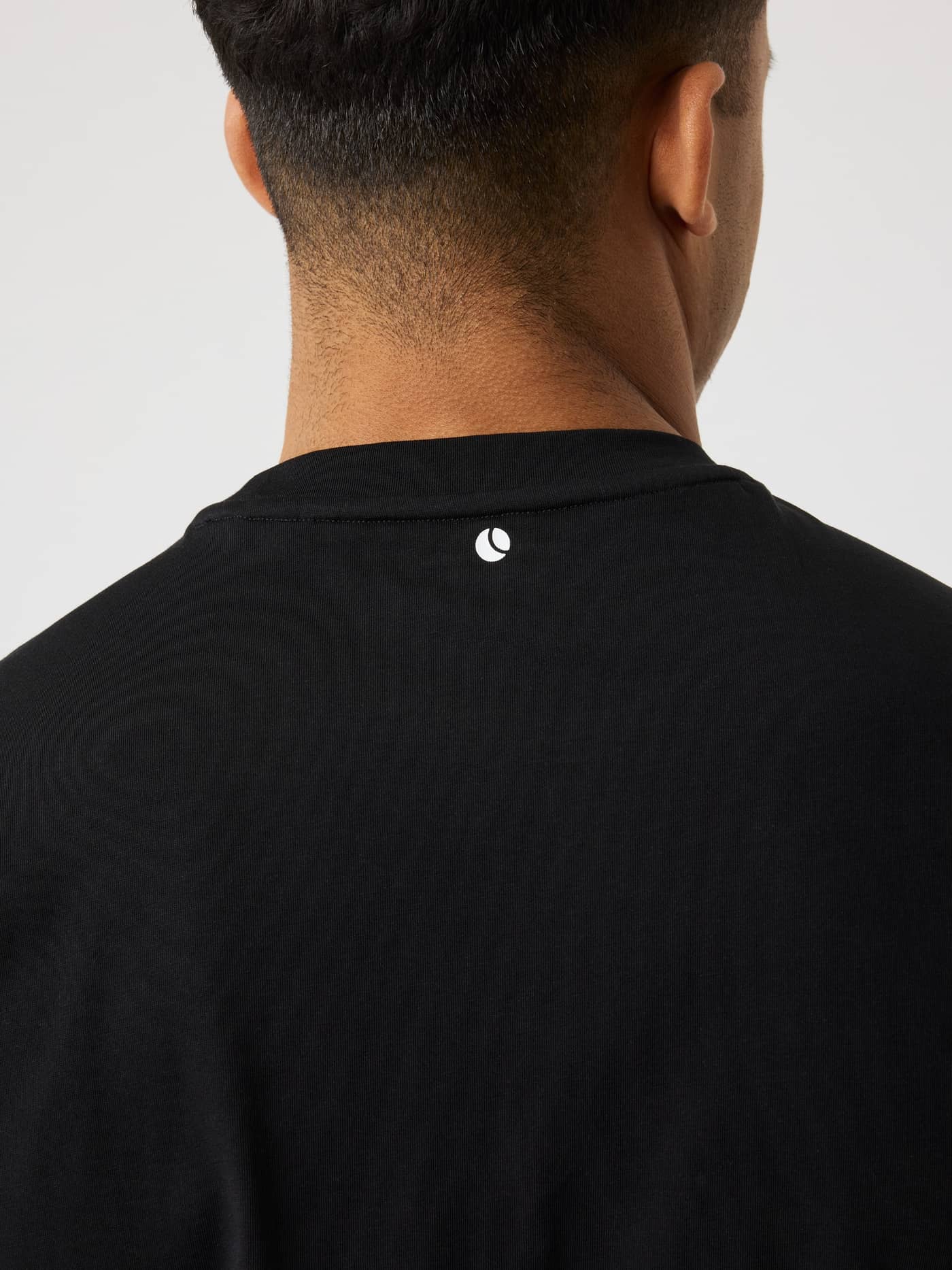 Close-up back view of the Borg Gym Sleeveless T-Shirt in Black Beauty (Black) with a white tennis ball logo for training. - Image 4
