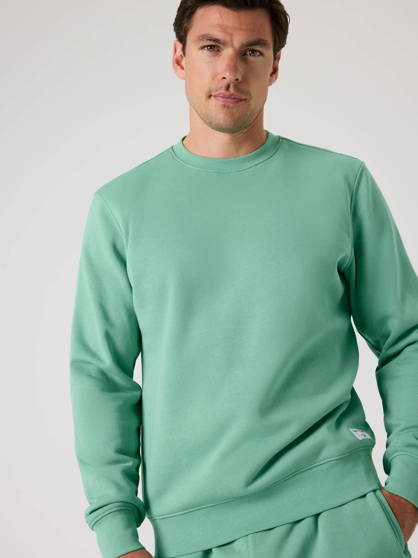 Front view of a man wearing the stylish, functional cotton-blend Björn Borg Centre Sweatshirt in Malachite Green (Green). - Image 1