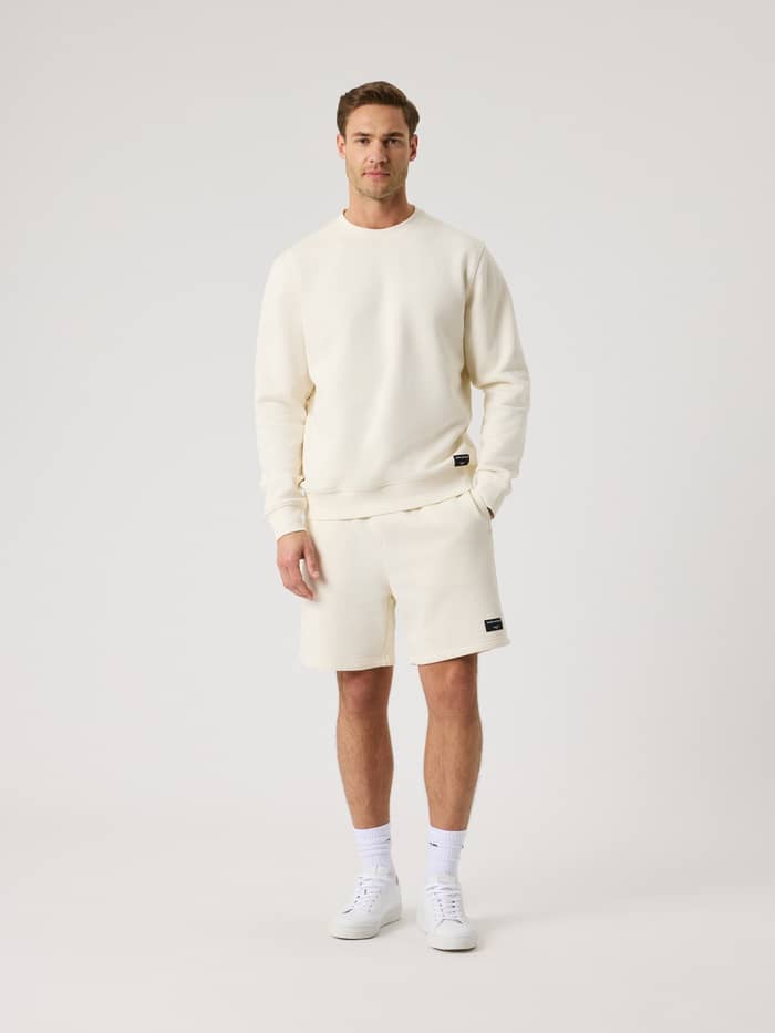 Vue de face d'un homme en Centre Sweatshirt Tofu (Blanc) et short assorti pour un style décontracté et confortable. - Image 3