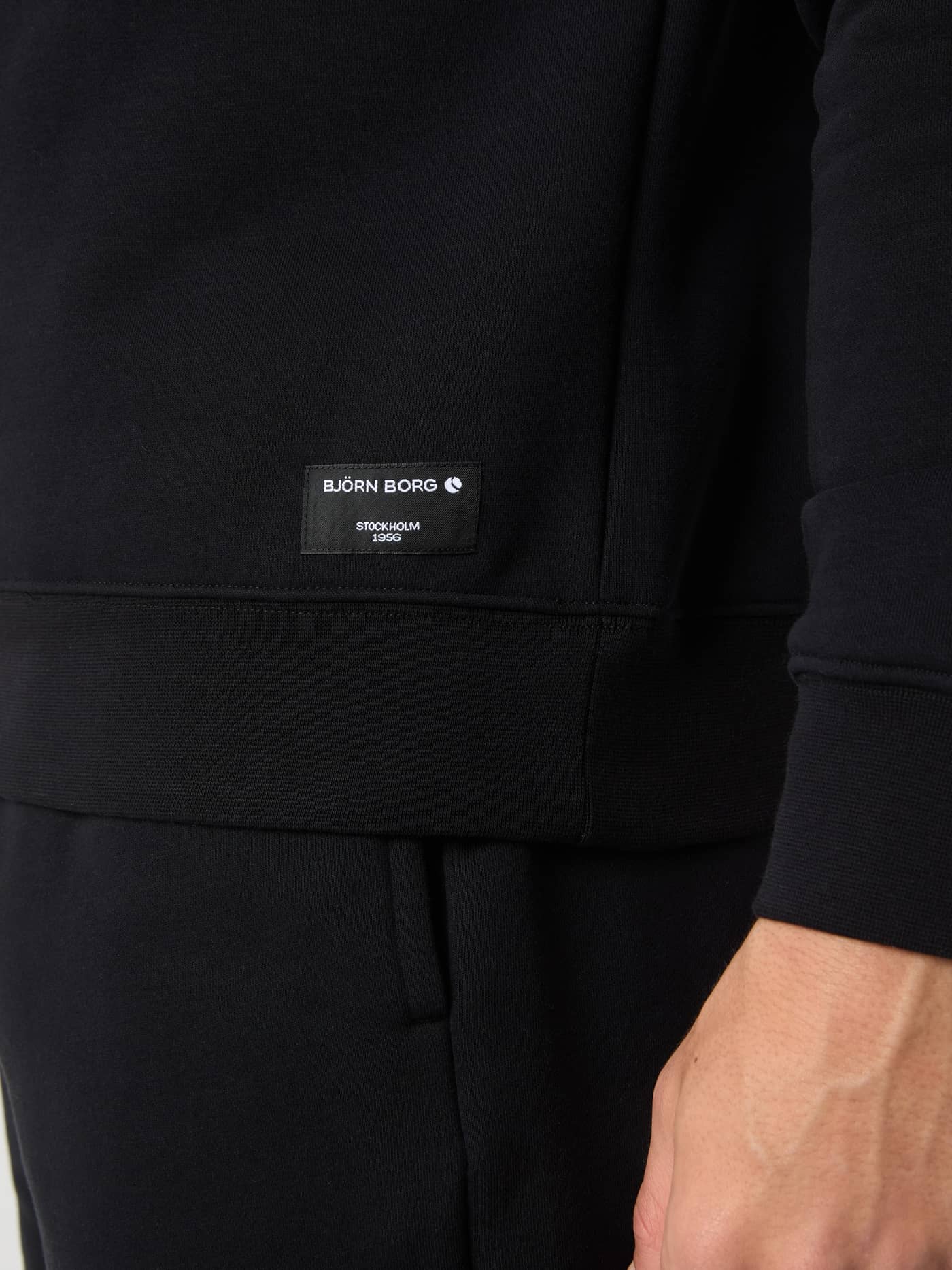 Detail van het witte geweven Björn Borg-logolabel op de zoom van het Centre Sweatshirt in Black Beauty (Zwart). - Image 4