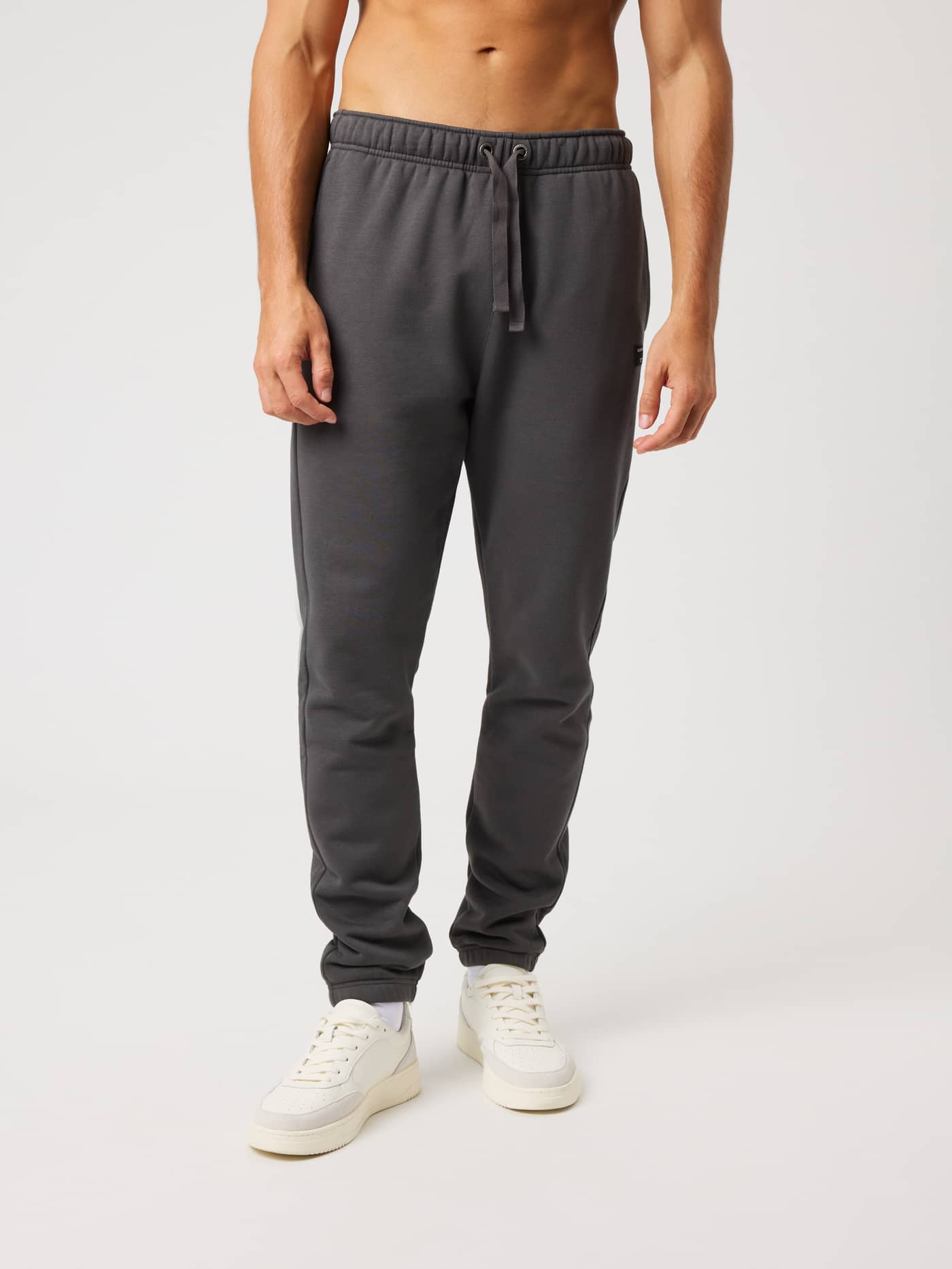 Vue de face du Centre Sweatpants en Asphalt (Noir) avec coupe décontractée et cordon de serrage à la taille. - Image 1