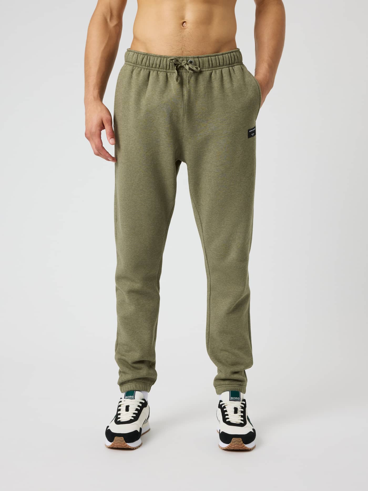 Vue de face d'un homme portant le Centre Sweatpants en Winter Moss Melange (Vert) avec cordon de serrage et logo noir. - Image 1