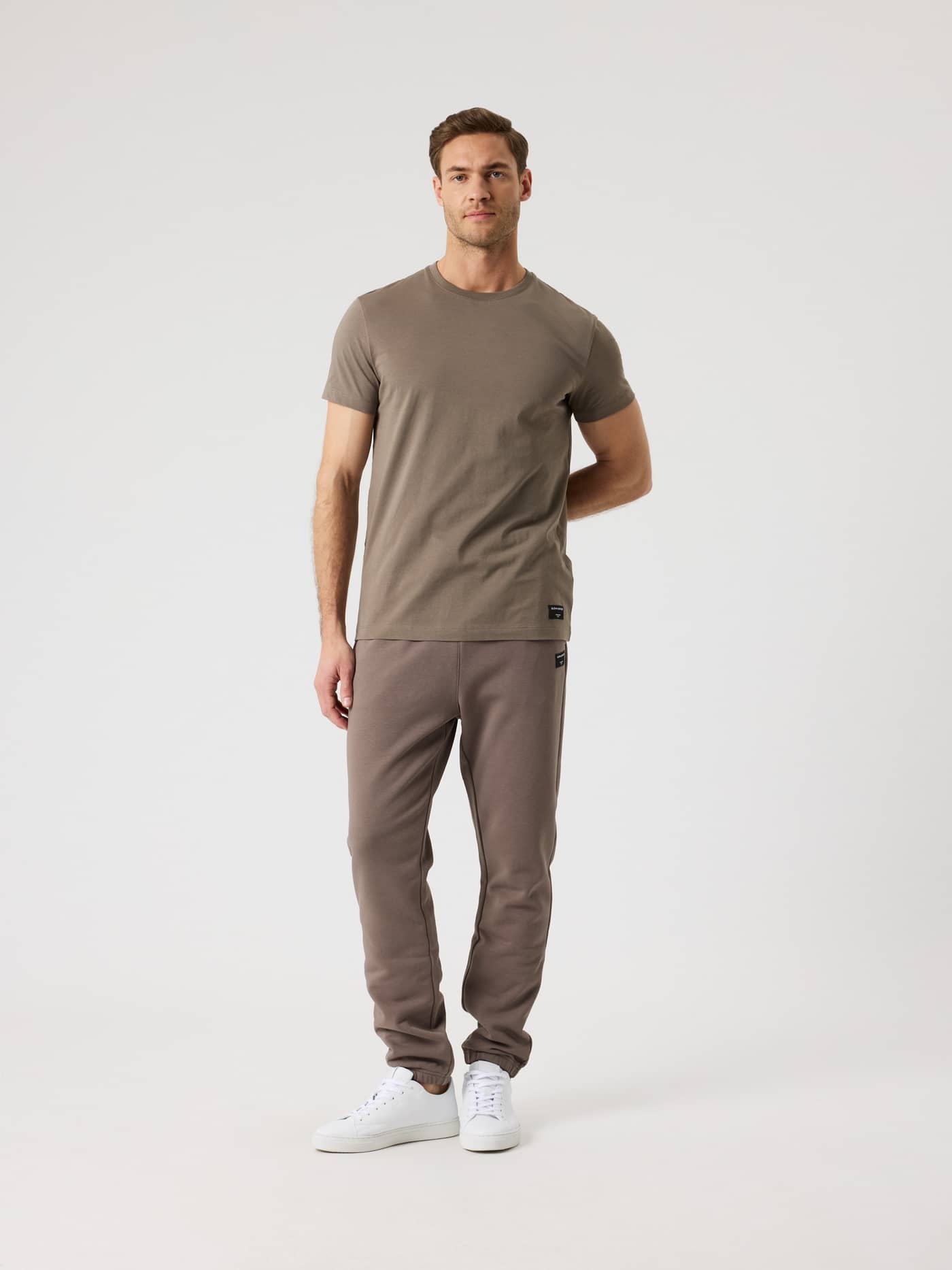 Full-body front view of a man wearing the Björn Borg Centre Sweatpants in Falcon (Brown) featuring a regular fit. - Image 3