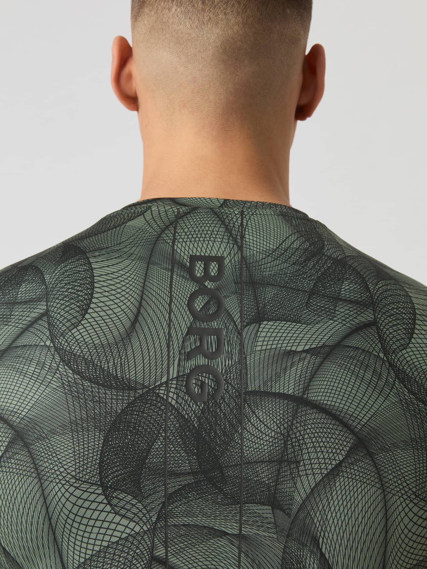 Nærbillede bagfra af Ace Printed T-Shirt i Big Grid 1 (Grøn) med sort lodret logo og grafisk tennisprint. - Image 5
