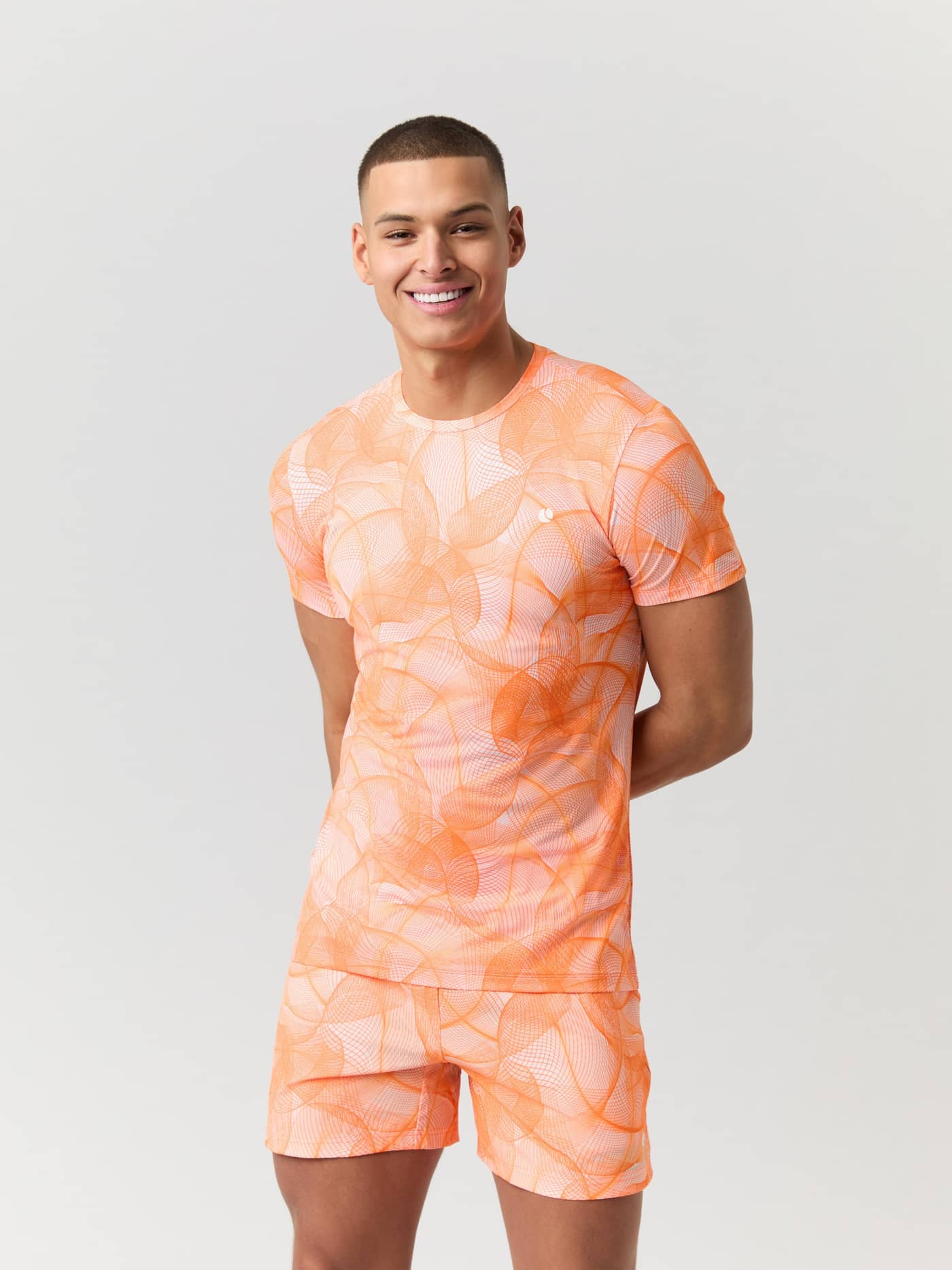 Vorderansicht eines Mannes im Björn Borg Ace Printed T-Shirt in Big Grid 2 (Orange) mit weißem Logo für Tennis. - Image 1