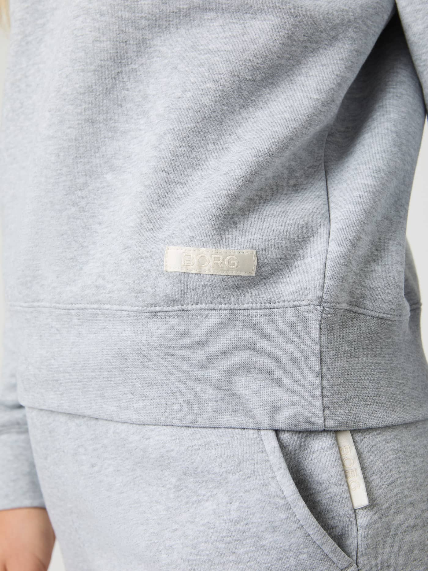 Detailed close-up of the off-white woven logo label on the women's Centre Sweatshirt in Light Grey Melange (Grey). - Image 4