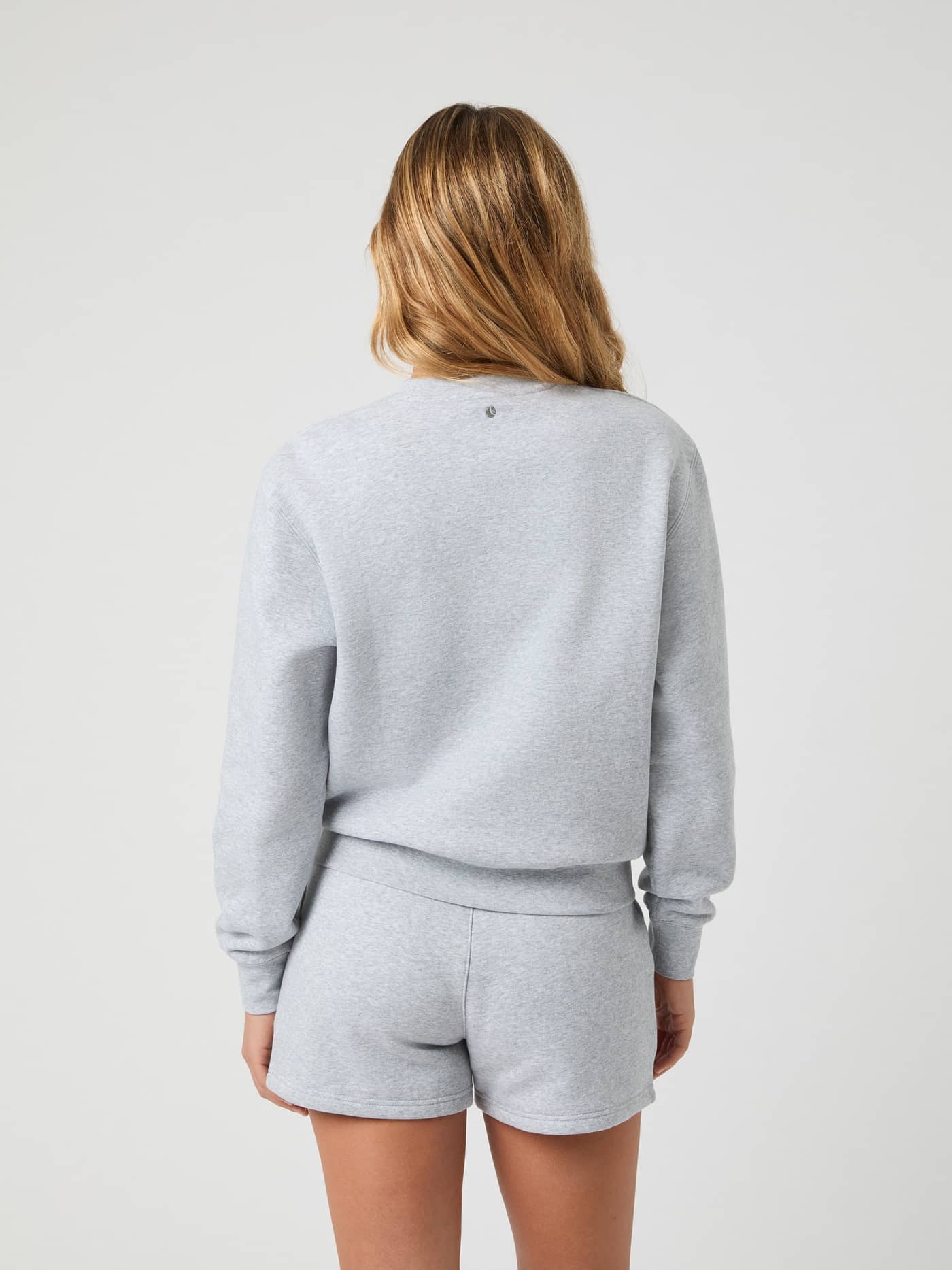 Back view of a woman wearing the Björn Borg Centre Sweatshirt in Light Grey Melange (Grey) for a stylish, regular fit. - Image 2