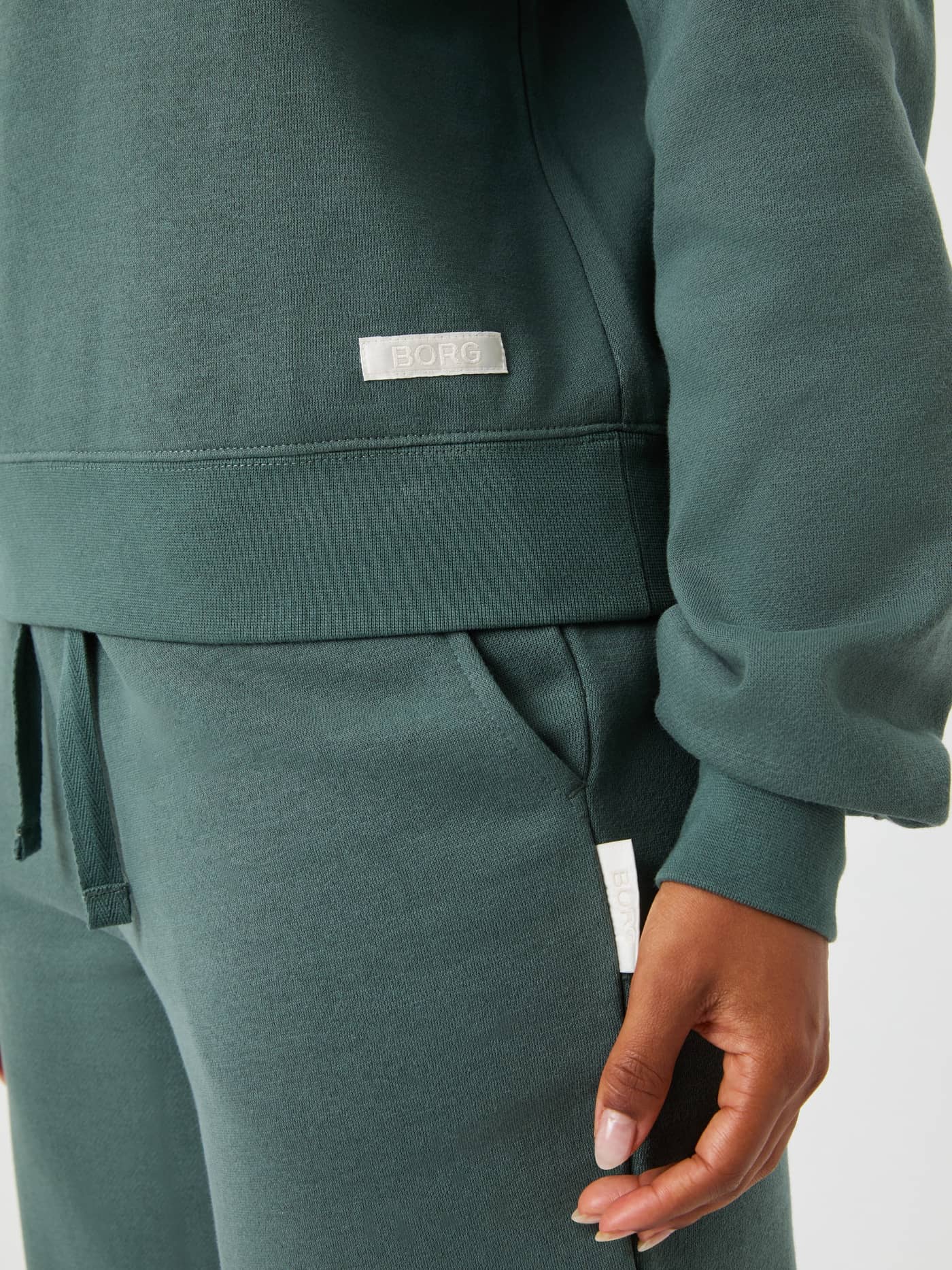 Detailed close-up of the Björn Borg Centre Sweatshirt in Balsam Green (Green), showcasing the white woven logo label. - Image 5