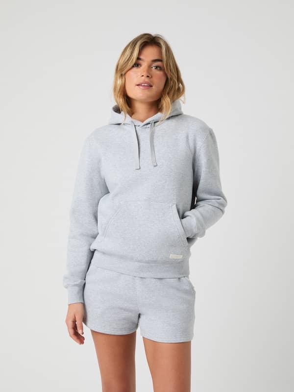 Front view of a woman wearing the oversized Björn Borg Centre Hoodie in light grey melange (grey) soft cotton fleece.