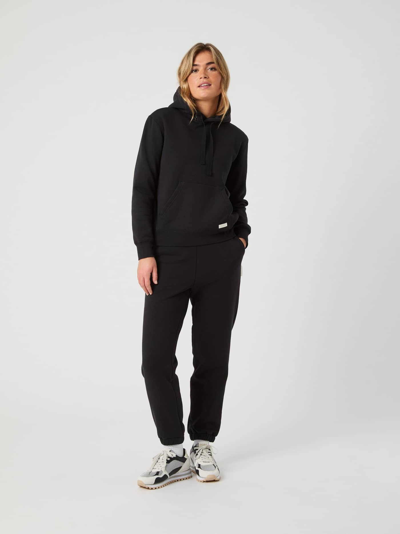 Vue de face d'une femme portant le Centre Hoodie surdimensionné en Black Beauty (Noir) au style décontracté. - Image 3