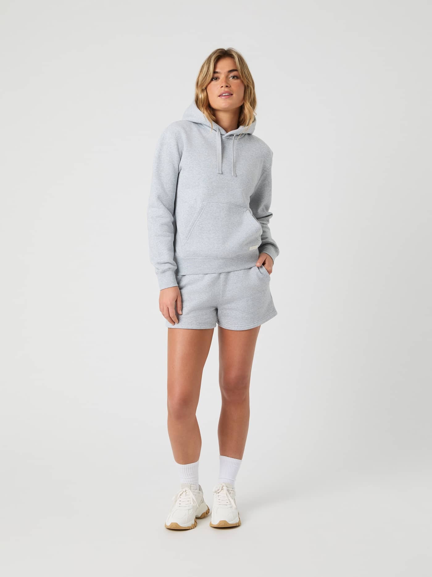 Full-body front view of a woman in the Björn Borg Centre Hoodie in Light Grey Melange (Grey) for a stylish, oversized fit. - Image 3