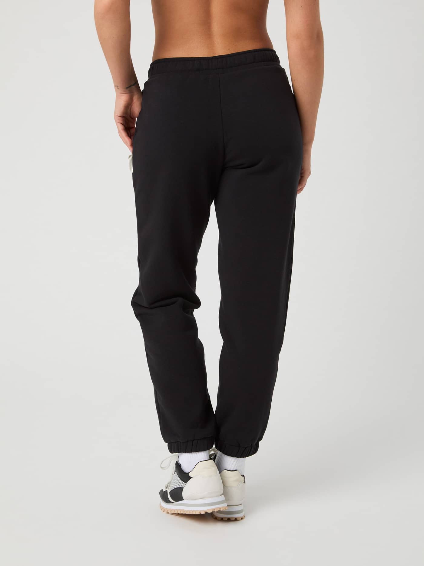Back view of a woman wearing the Björn Borg Centre Sweatpants in Black Beauty (Black) with a soft and regular fit. - Image 3