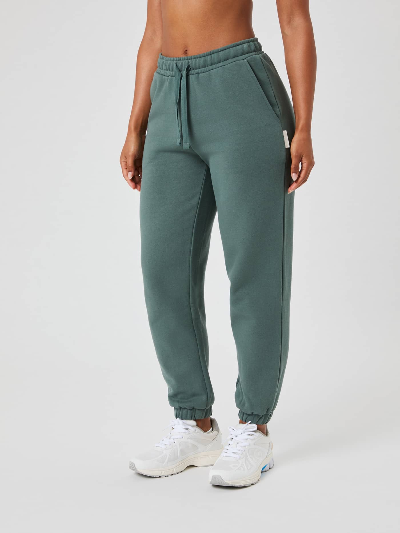 Front view of a woman wearing the regular fit Björn Borg Centre Sweatpants in Balsam Green (Green) in soft fleece. - Image 2