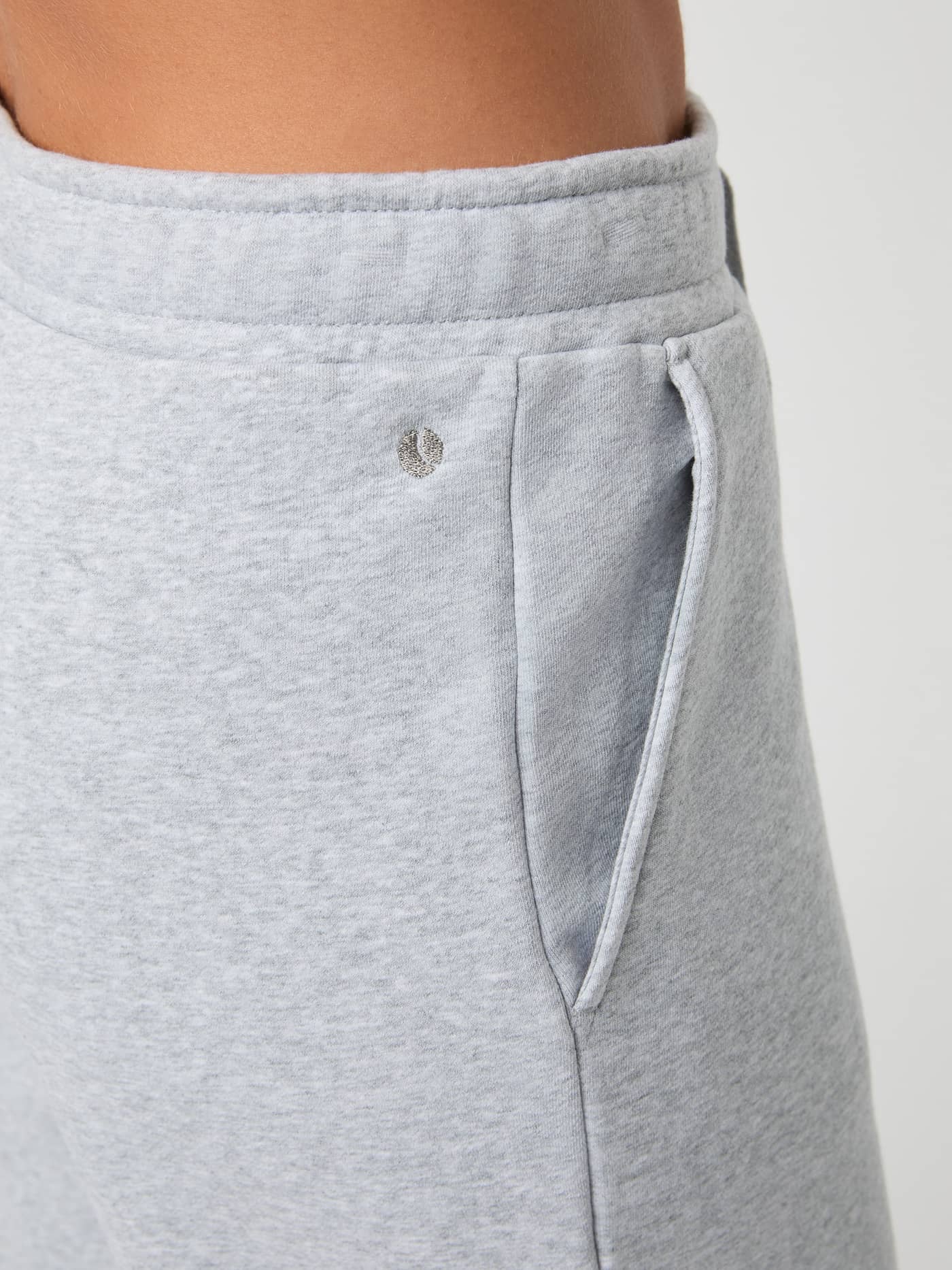 Close-up of the women's Centre Sweatpants in Light Grey Melange (Grey) featuring a side pocket and grey logo detail. - Image 5