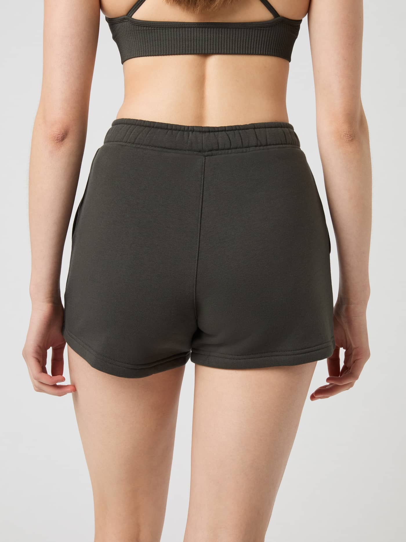 Back view of a model wearing the Björn Borg Centre Sweatshorts in Peat (Green), featuring a comfortable regular fit. - Image 3