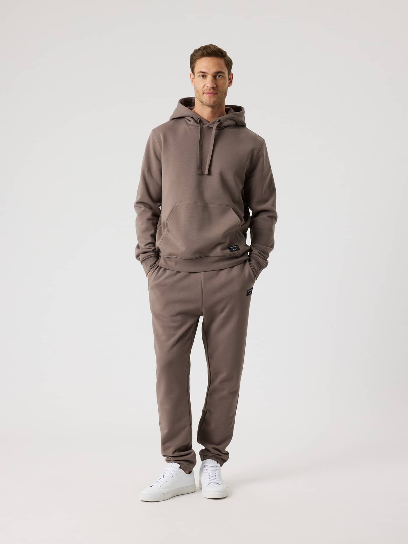 Man in de Björn Borg Centre Hoodie in Falcon (Bruin) met bijpassende sweatpants in vooraanzicht voor een stijlvolle fit. - Image 3