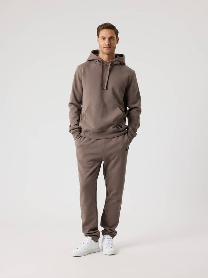 Full-body front view of a man wearing the Björn Borg Centre Hoodie in Falcon (Brown) with matching sweatpants. - Image 3