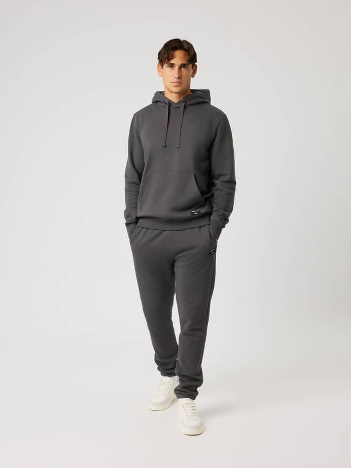 Volledig vooraanzicht van de Centre Hoodie in Asphalt (Grijs) met een kangoeroezak en een zwart logolabel. - Image 3