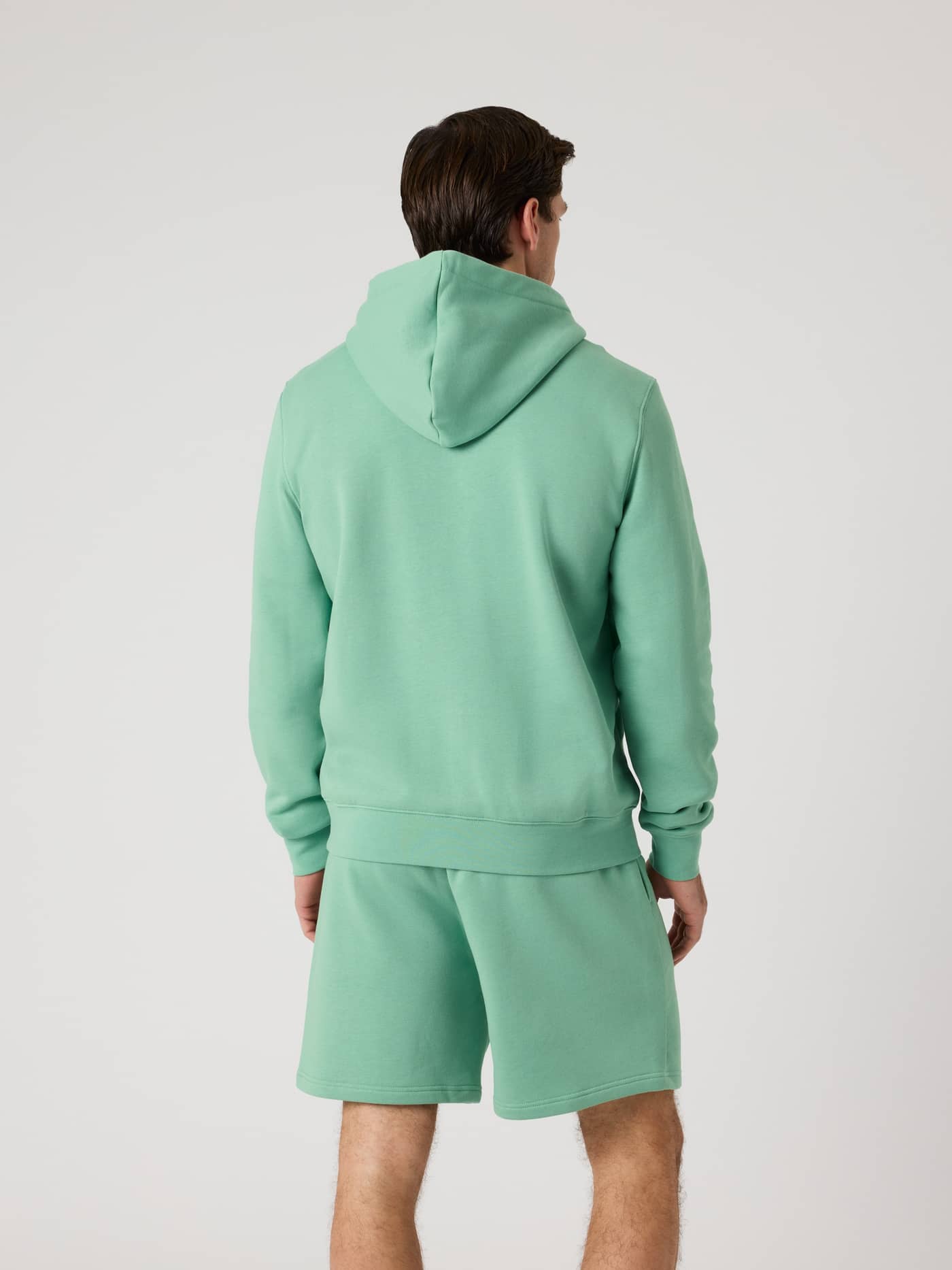Rückansicht eines Mannes im Björn Borg Centre Hoodie in Malachite Green (Grün) kombiniert mit passenden Shorts. - Image 3