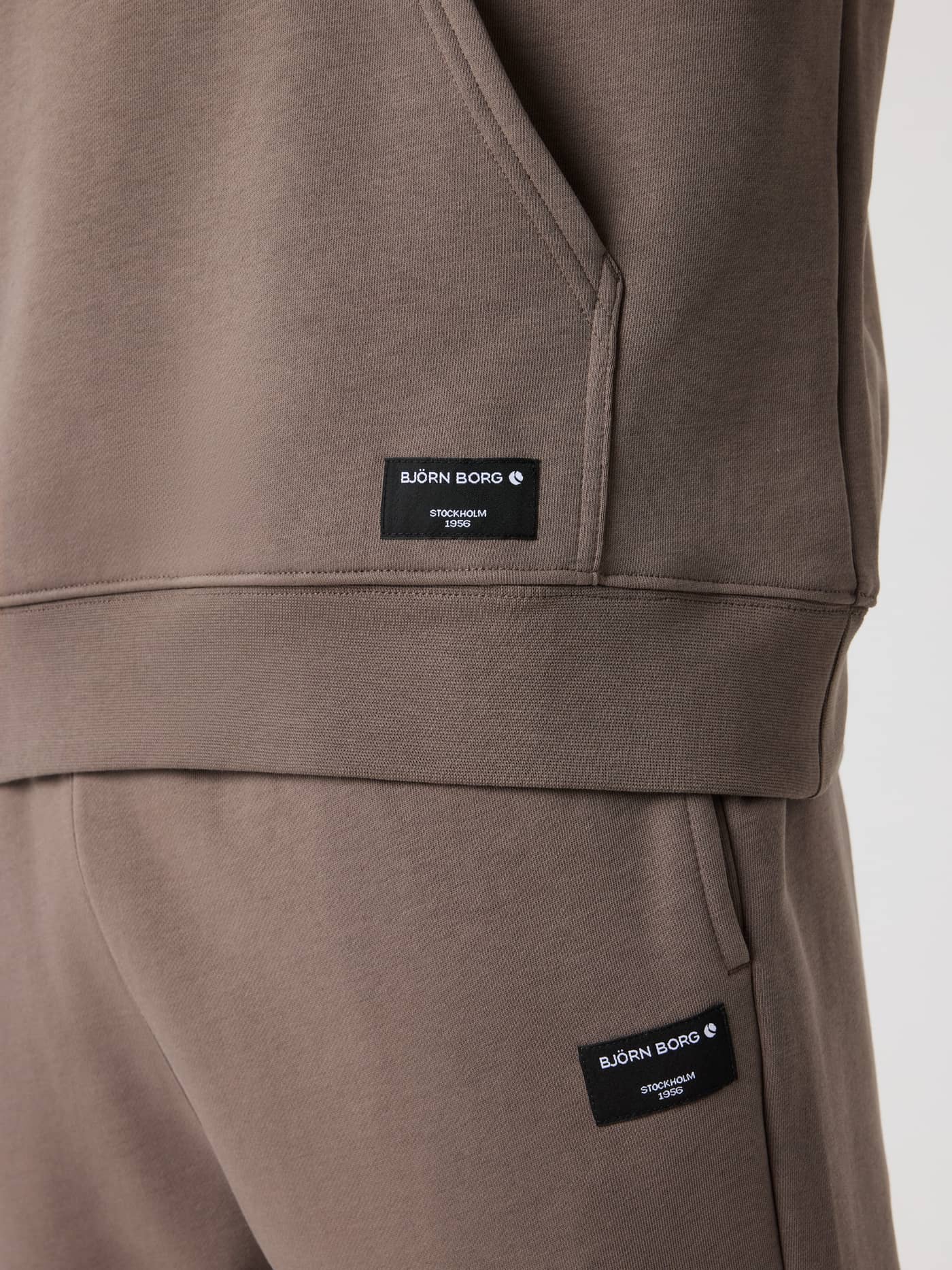 Zwarte geweven logolabels op de Falcon (Bruin) Centre Hoodie en bijpassende broek voor heren in detailopname. - Image 4