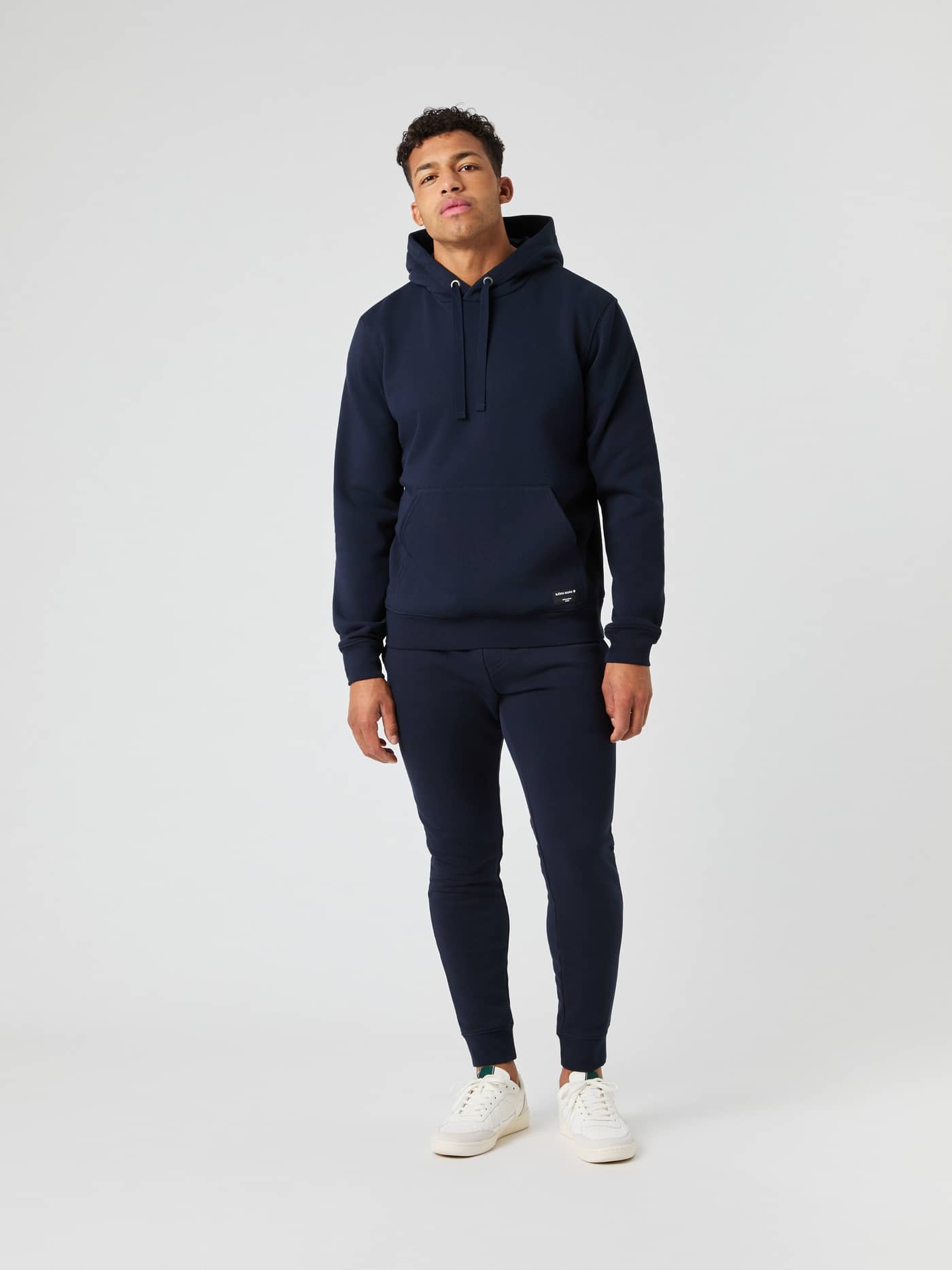 Male model in a full-length shot wearing the Björn Borg Centre Hoodie in navy with matching sweatpants. - Image 3