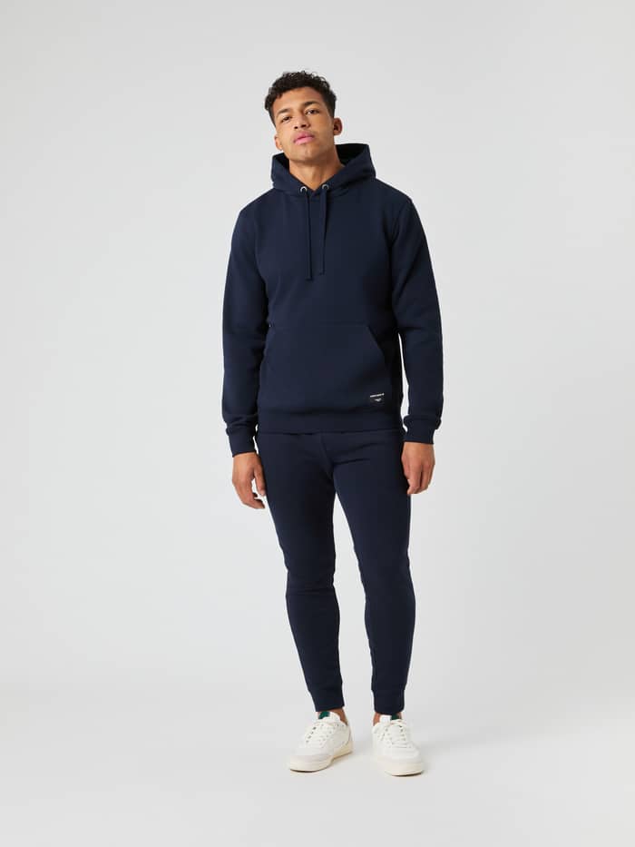Male model in a full-length shot wearing the Björn Borg Centre Hoodie in navy with matching sweatpants.