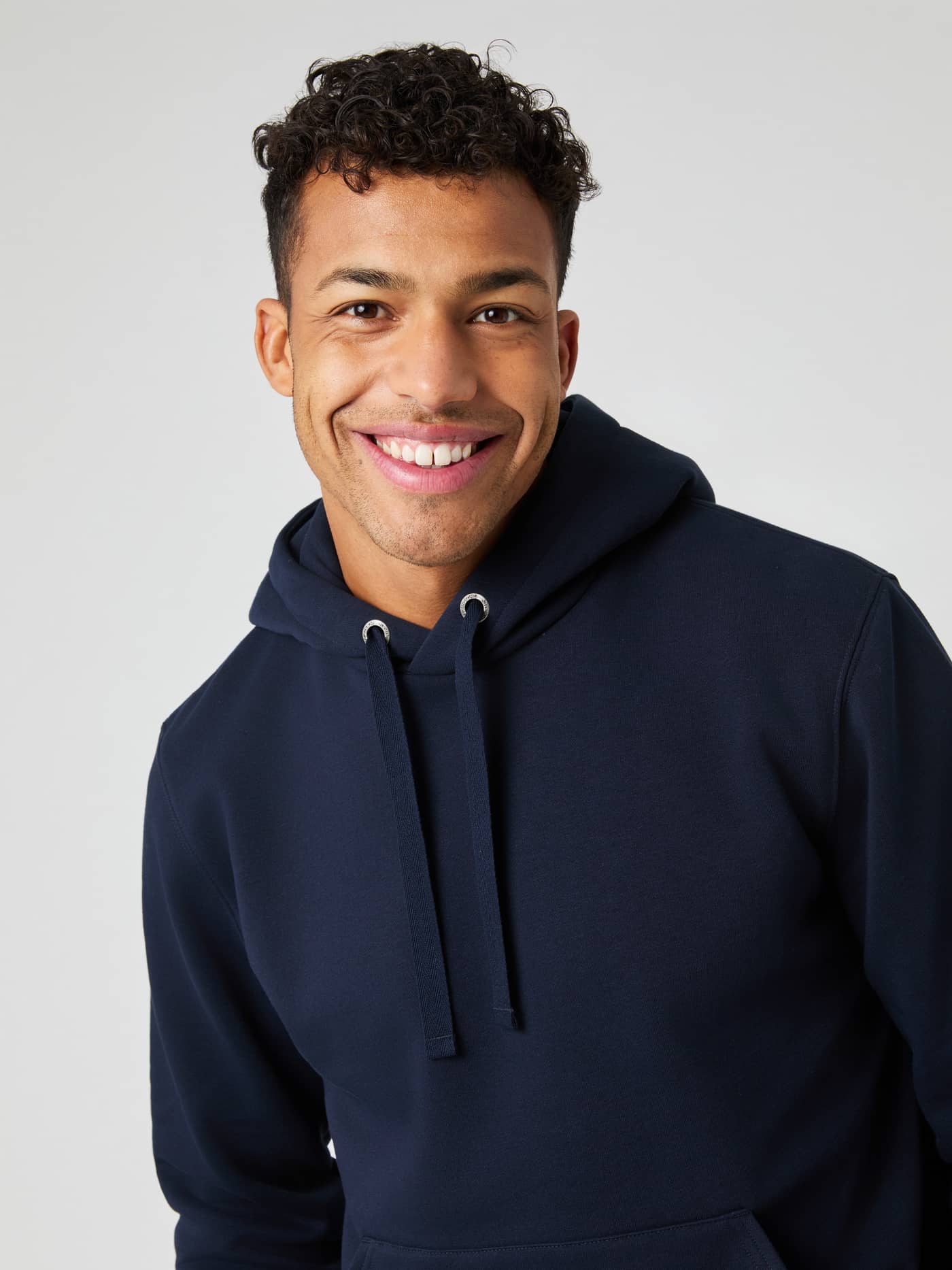 Close-up of a smiling man wearing the navy blue Björn Borg Centre Hoodie. - Image 4